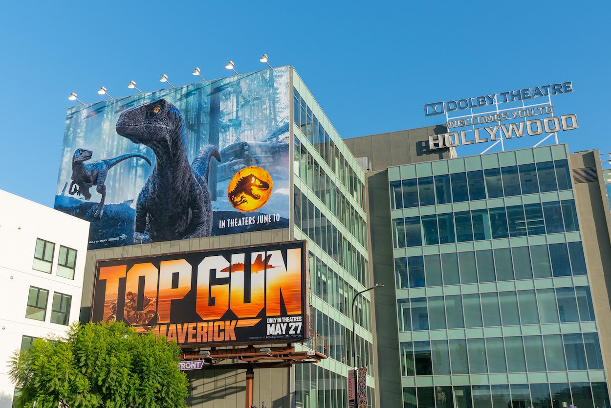 'Jurassic World Dominion' and 'Top Gun: Maverick' posters outside the Dolby Theatre sign in Hollywood, California. 'Maverick's massive success could impact 'Jurassic World Dominion' and 'Lightyear' in a good way.