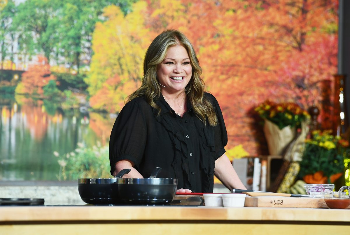 Food Network personality Valerie Bertinelli wears a black blouse as she prepares a dish.