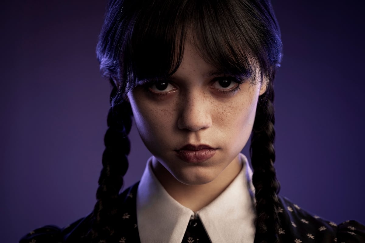 Jenny Ortega appears as Wednesday Addams in a scene from the 'Wednesday' Netflix series. She is dressed in black with her hair in pigtails.