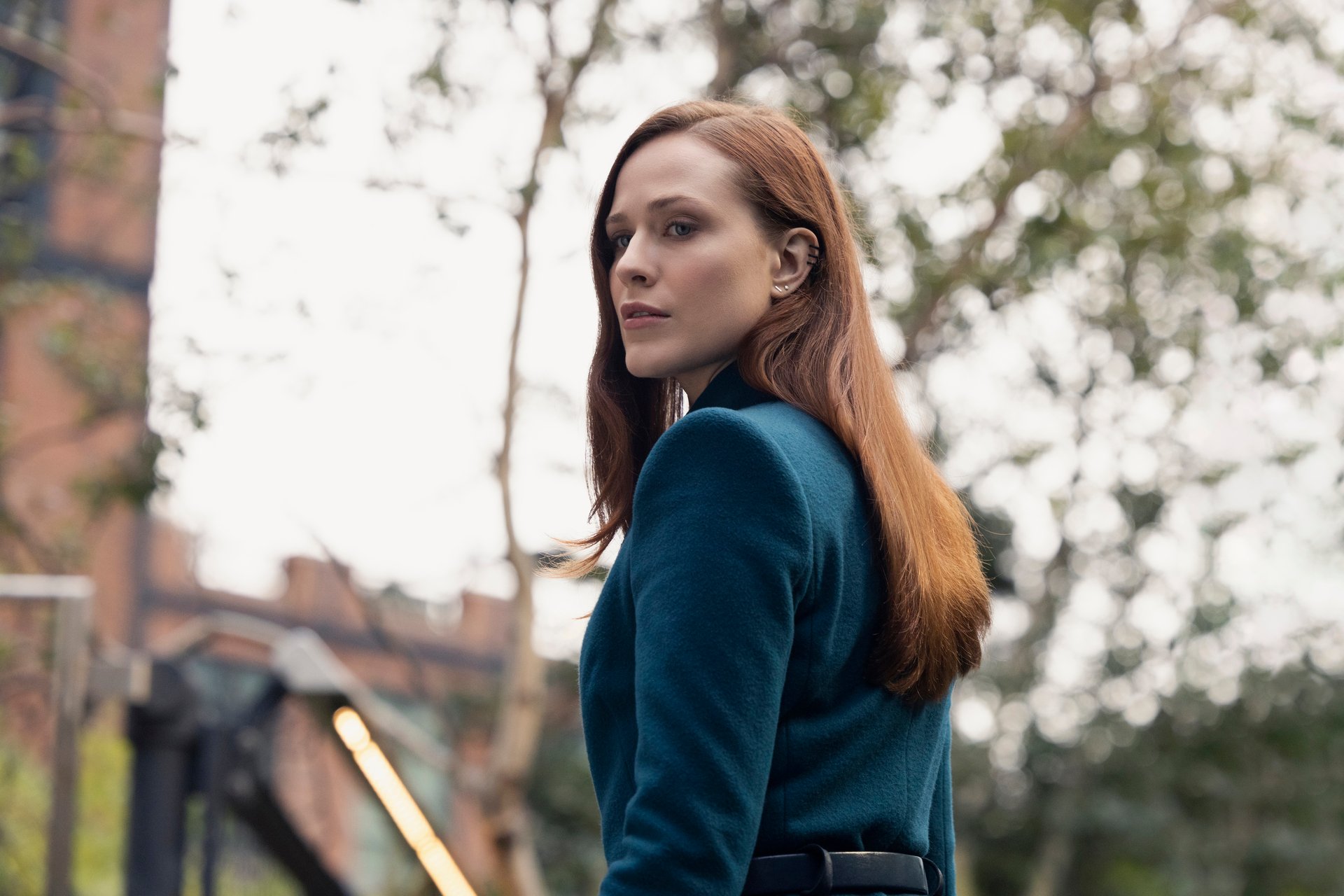 Evan Rachel Wood in 'Westworld' Season 4, which is approaching its release date. She's wearing a green suit, her hair is red, and she's looking over her shoulder.