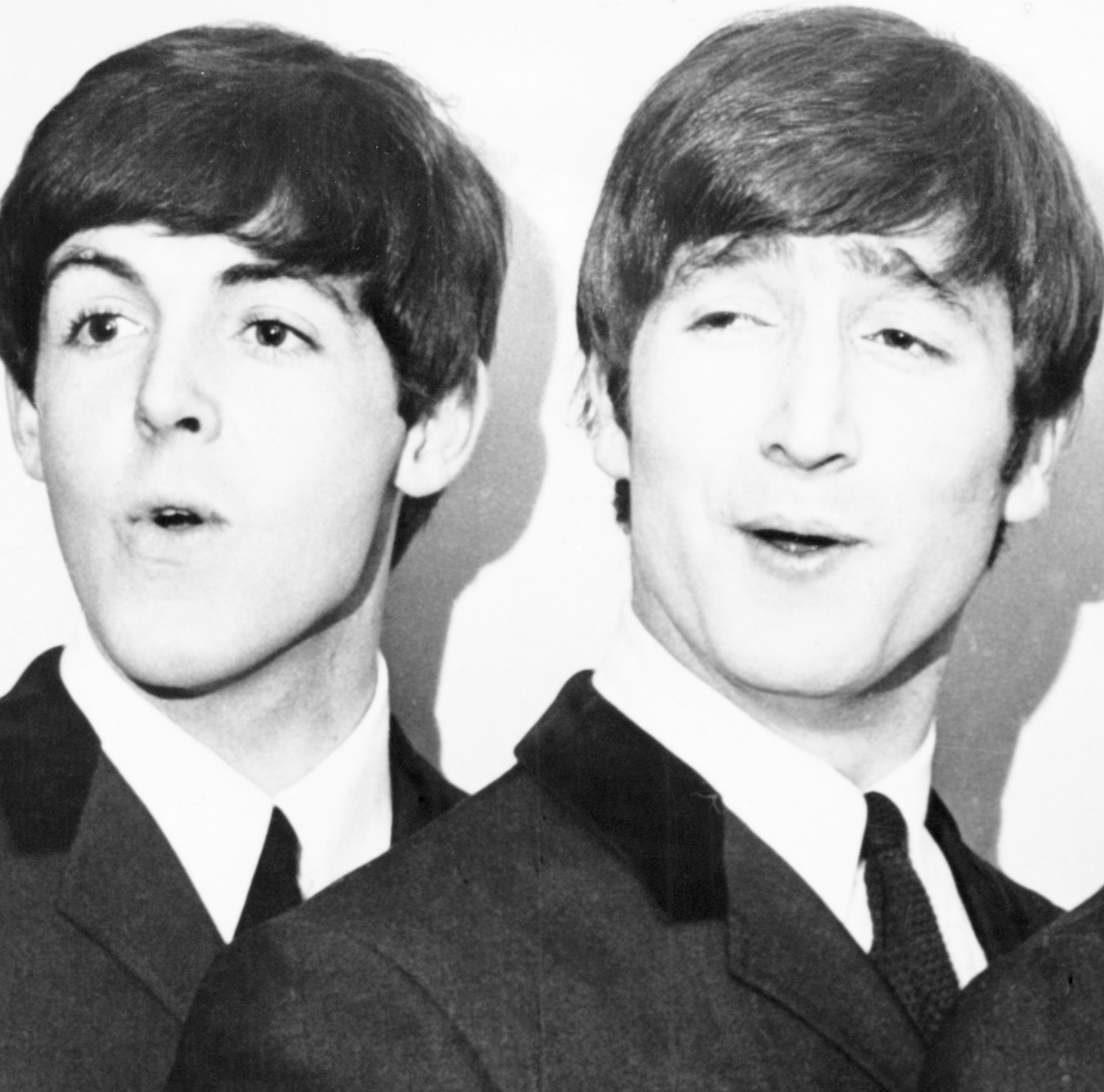 The Beatles' Paul McCartney and John Lennon wearing suits