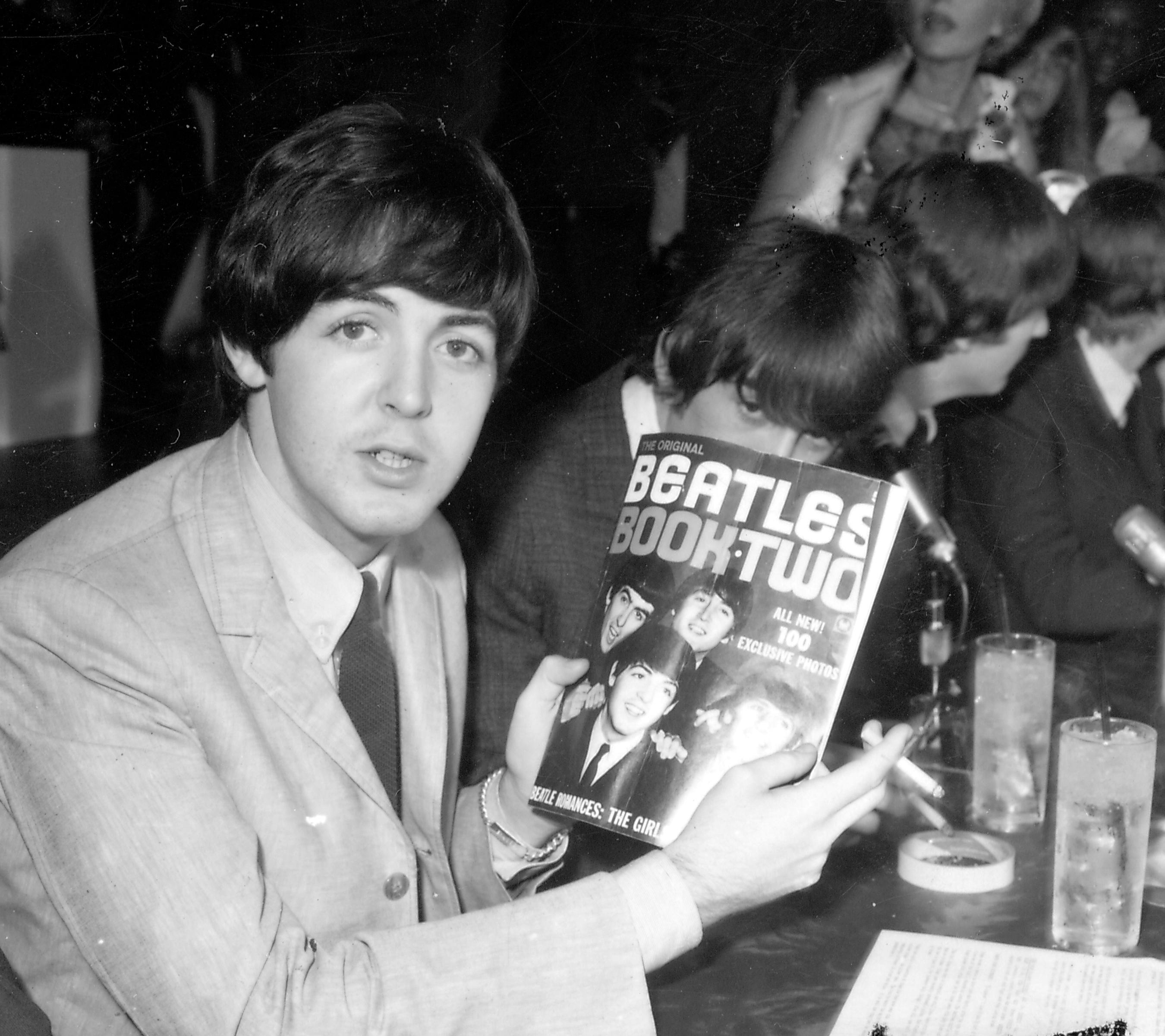 The Beatles' Paul McCartney holding a magazine