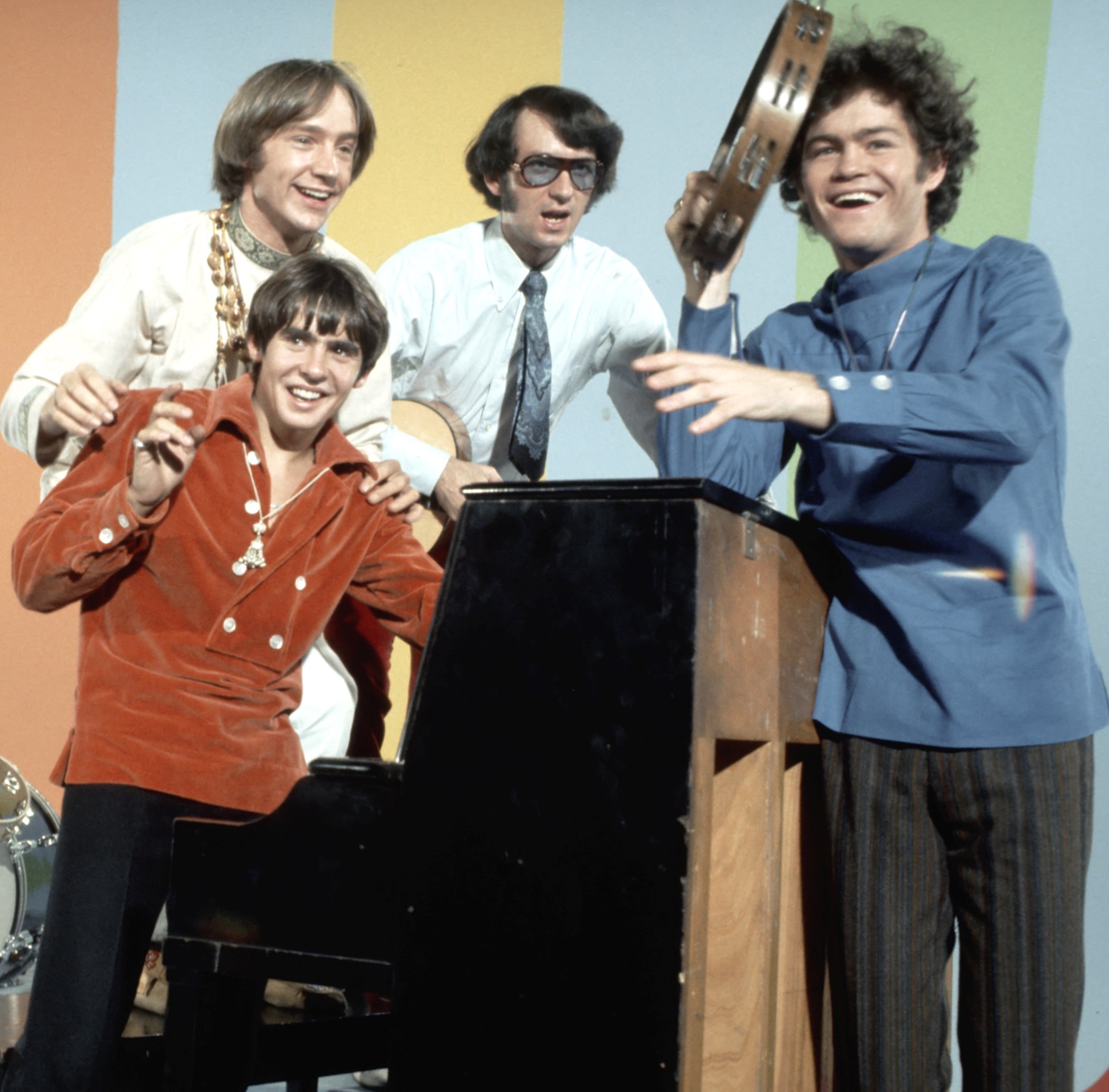 The Monkees' Peter Tork, Davy Jones, Mike Nesmith, and Micky Dolenz at a piano