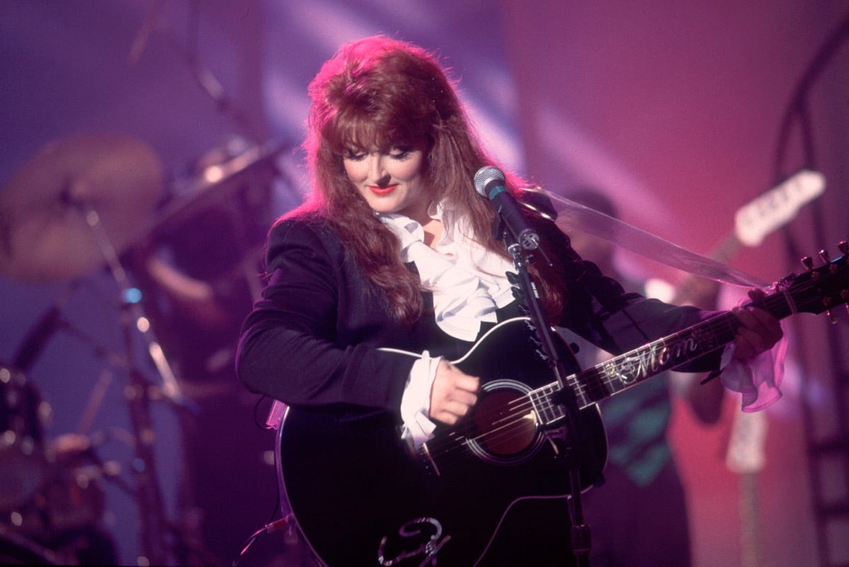 Wynonna Judd performs with her guitar three years before she had her daughter