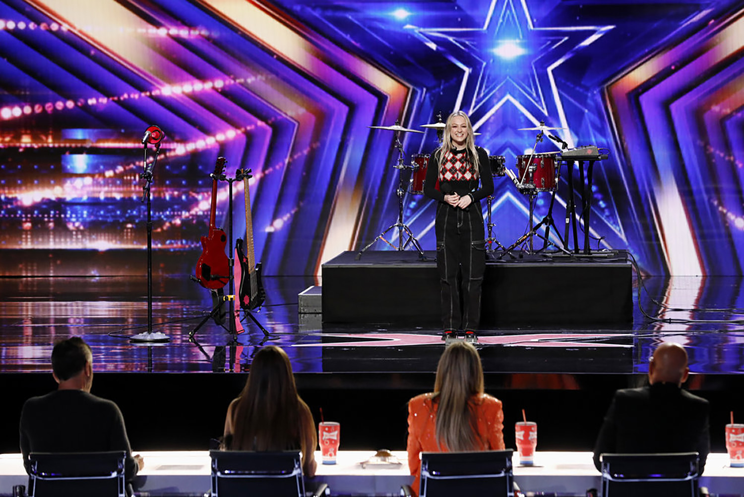 Americas Got Talent performer Mia Morris stands on stage in front of the judges.