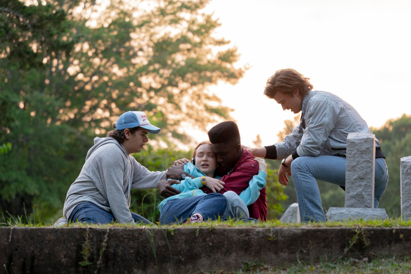 Dustin (Gaten Matarazzo), Max (Sadie Sink), Lucas (Caleb McLaughlin), and Steve (Joe Keery) at Billy's grave in 'Stranger Things' 4 Vol. 1