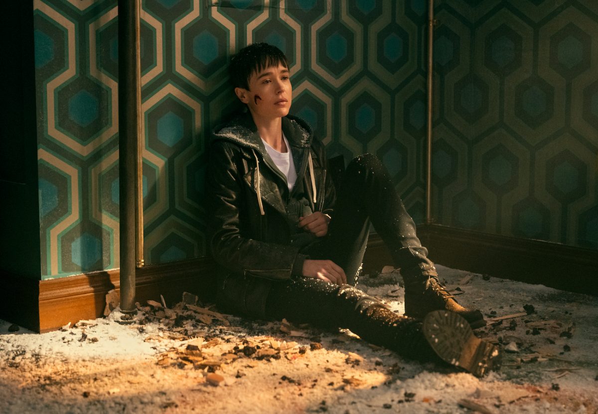 Viktor (Elliot Page), who announces his transition in season 3, sits against the wall bleeding from the cheek in 'The Umbrella Academy'