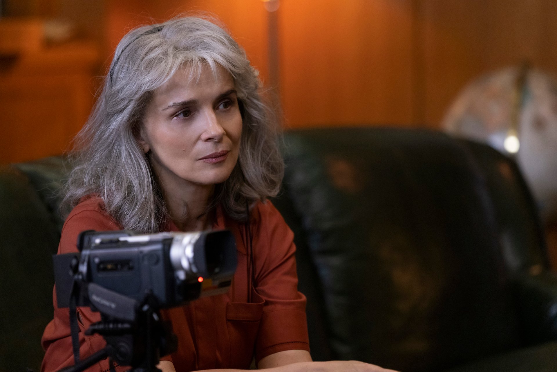Sophie Brunet (Juliette Binoche) sits with a camera in 'The Staircase' on HBO Max