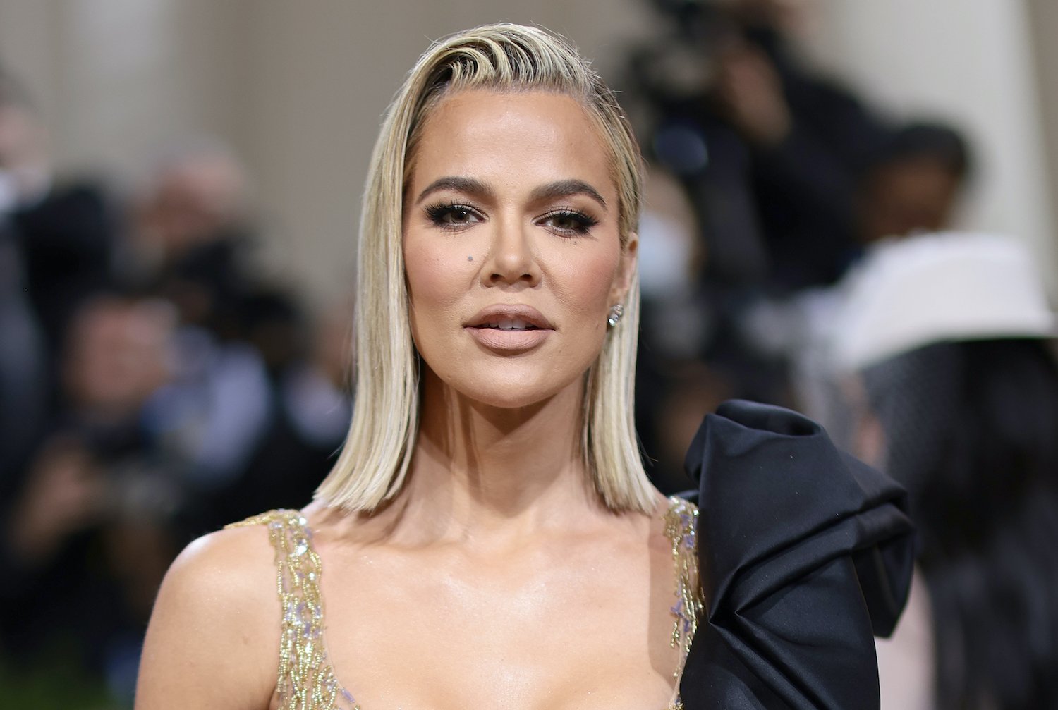 Khloe Kardashian, who appeared on 'Hot Ones,' poses at the 2022 Met Gala wearing a gold sequin dress