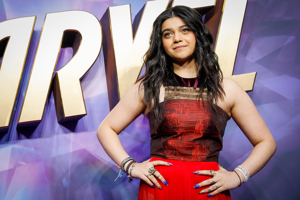 Iman Vellani attends the "Ms. Marvel" U.K. special screening, posing in front of the Disney+ series logo in a red and black dress.