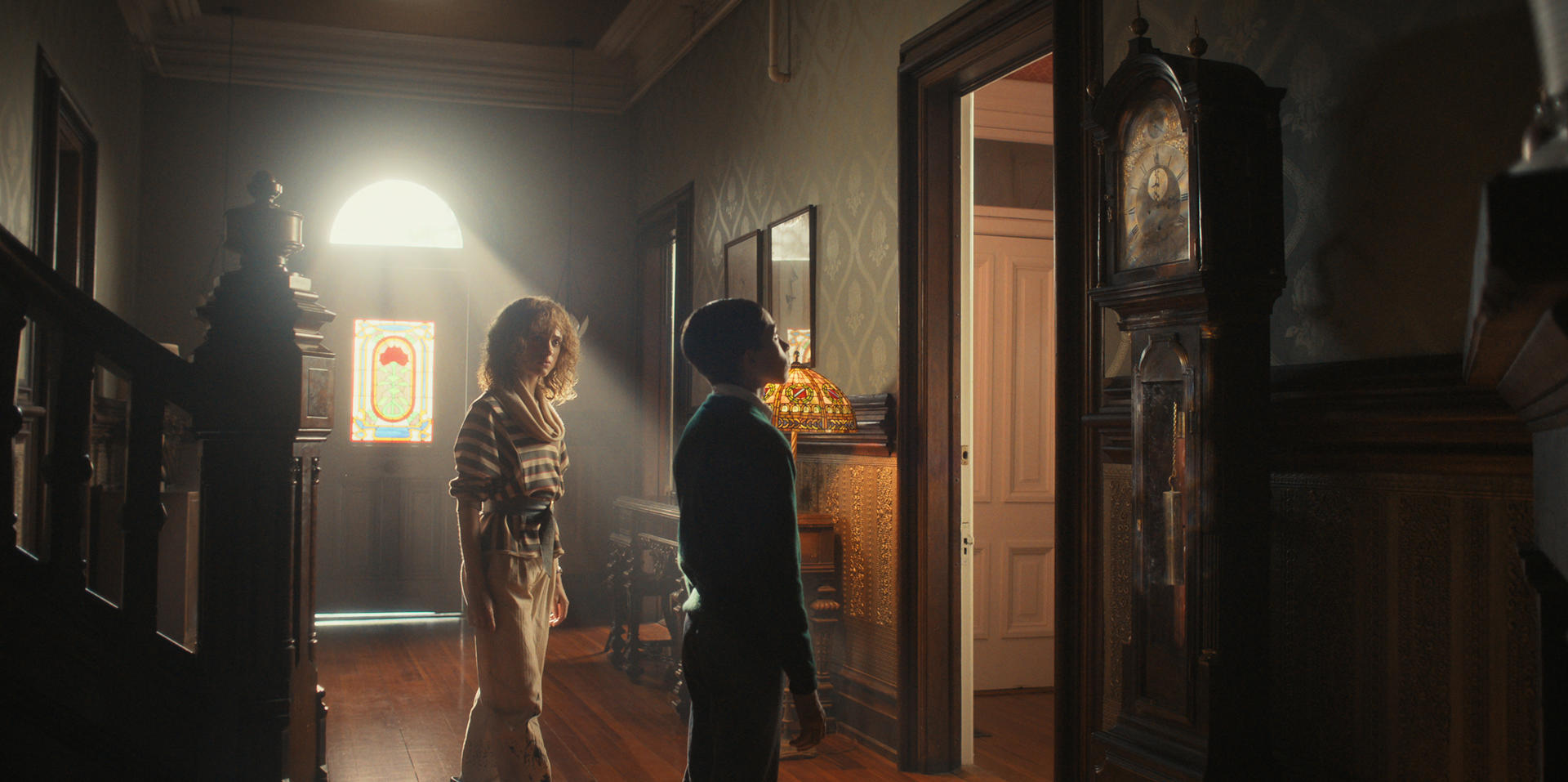 Nancy (Natalia Dyer) watches Henry Creel (Raphael Luce) stares at a grandfather clock in 'Stranger Things' 4 Vol. I