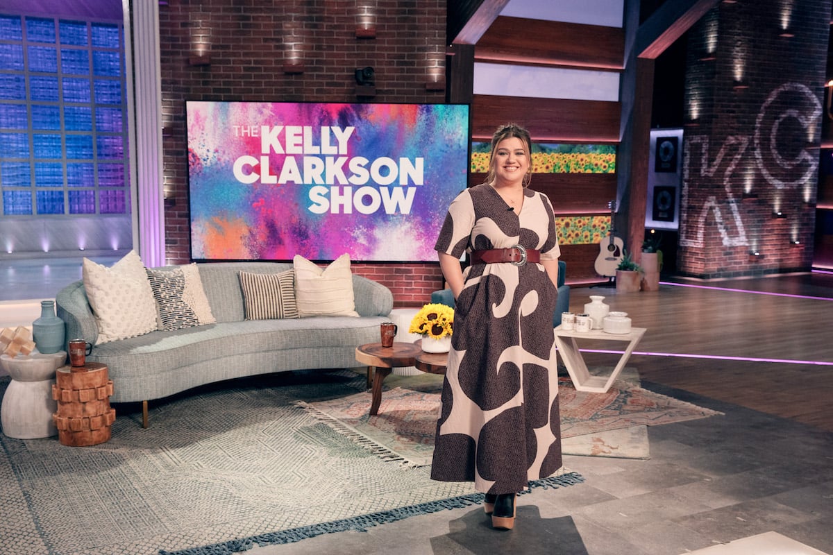 Kelly Clarkson standing smiling on the set of 'The Kelly Clarkson Show,' which has won and been nominated for multiple Daytime Emmys