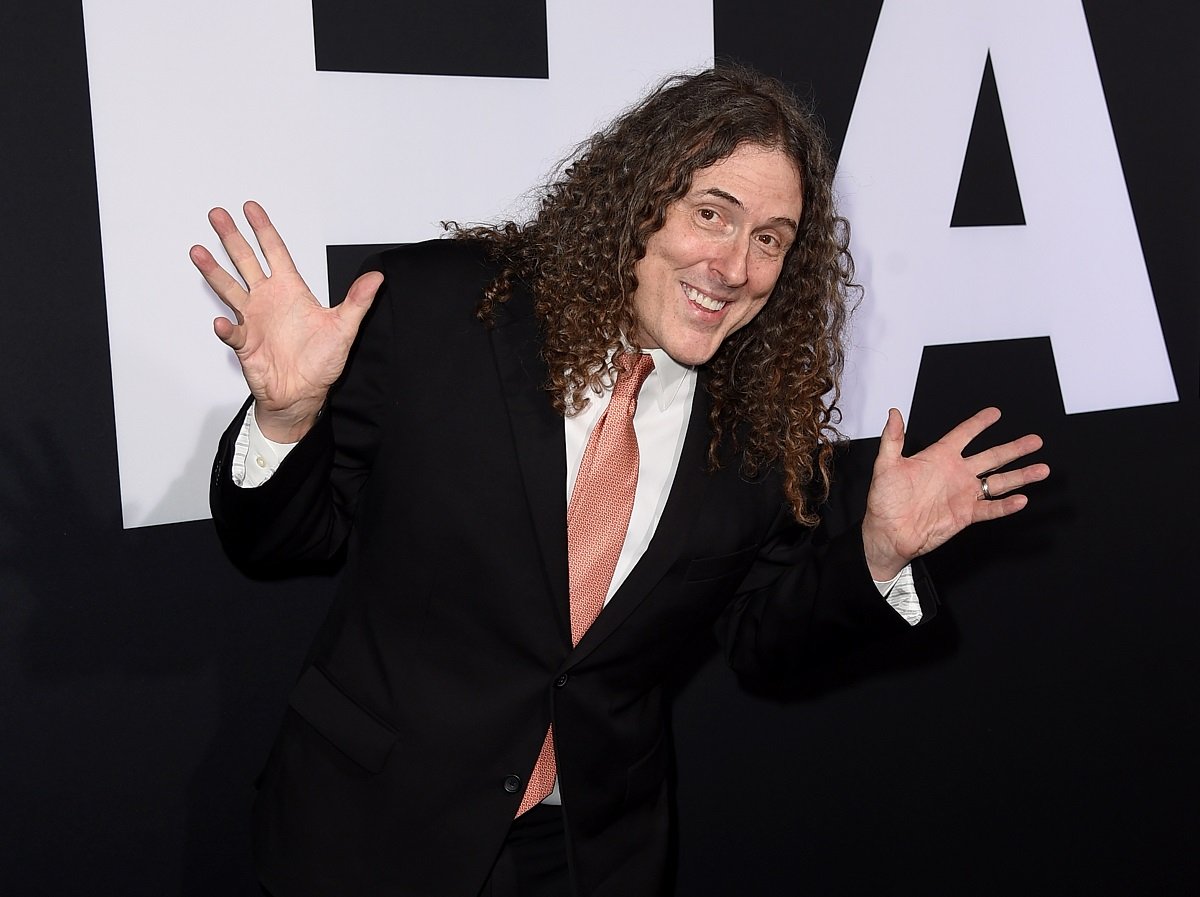 Weird Al Yankovic smiling and holding up his hands