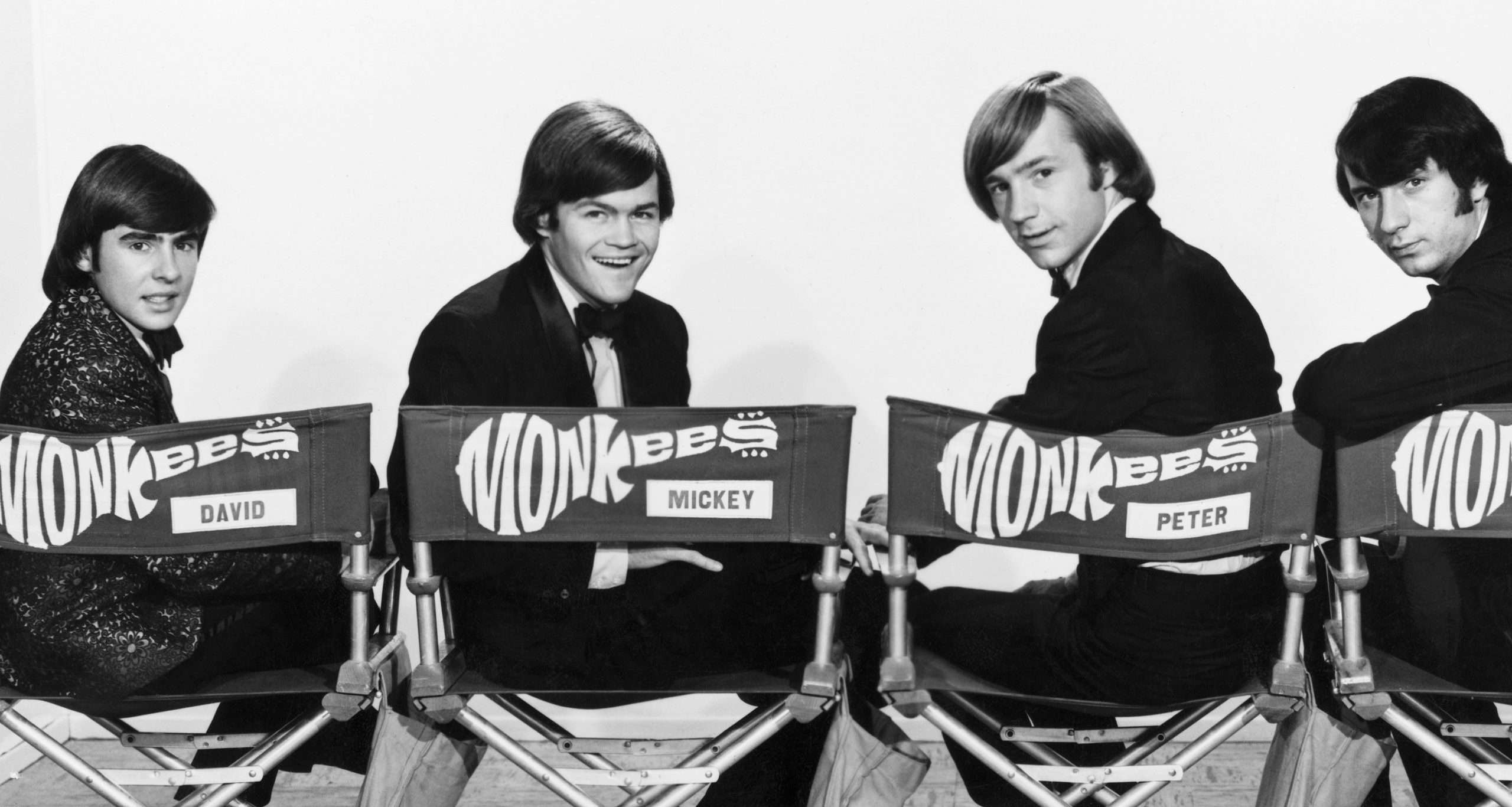The Monkees' Davy Jones, Micky Dolenz, Peter Tork, and Mike Nesmith in chairs