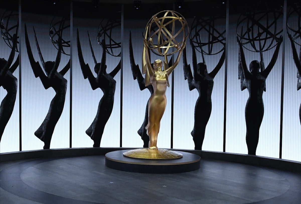 A giant replica of an Emmy Award next to a backdrop of shadowed Emmys