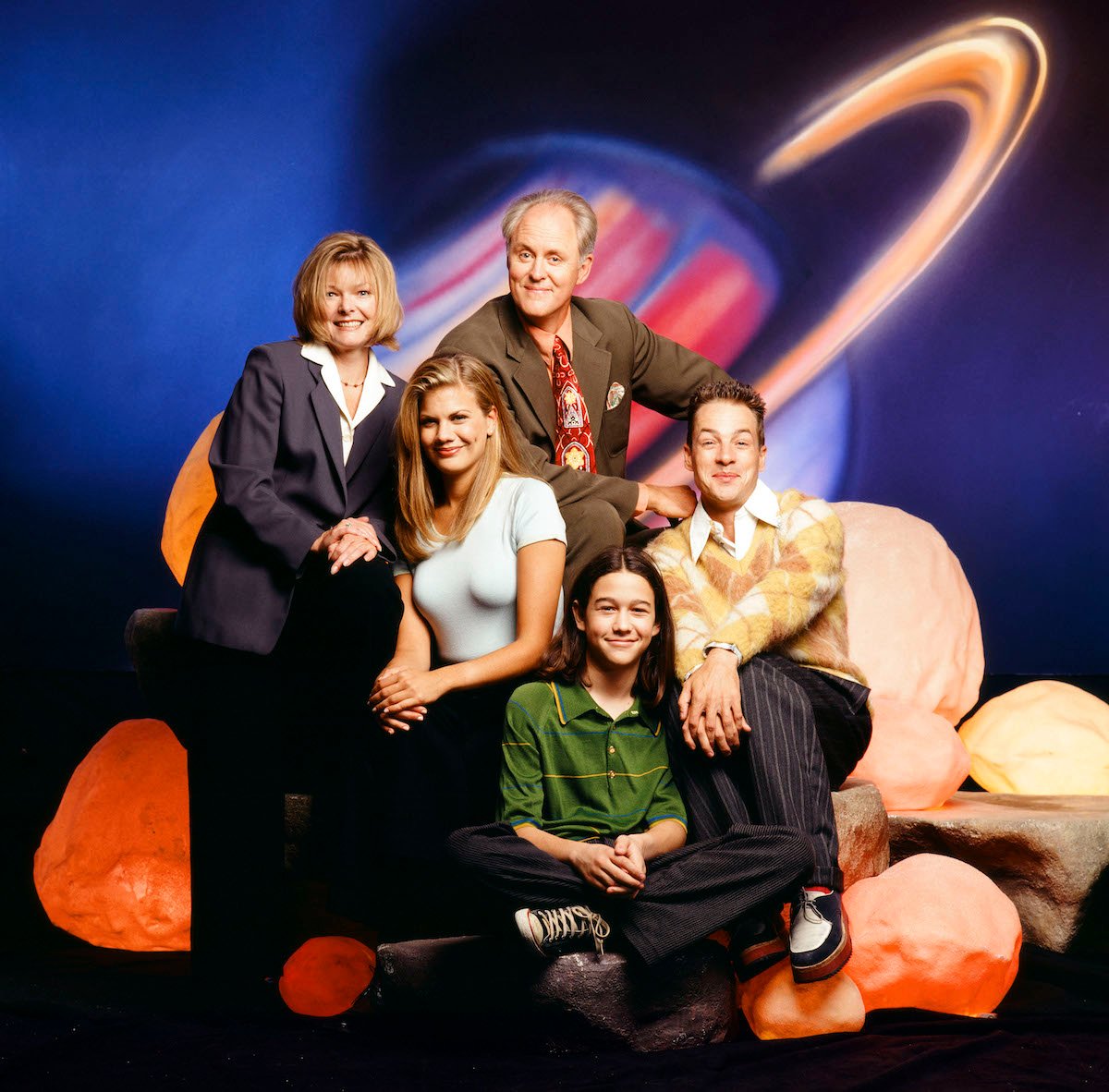The cast of 3rd Rock from the Sun poses in front of a planet