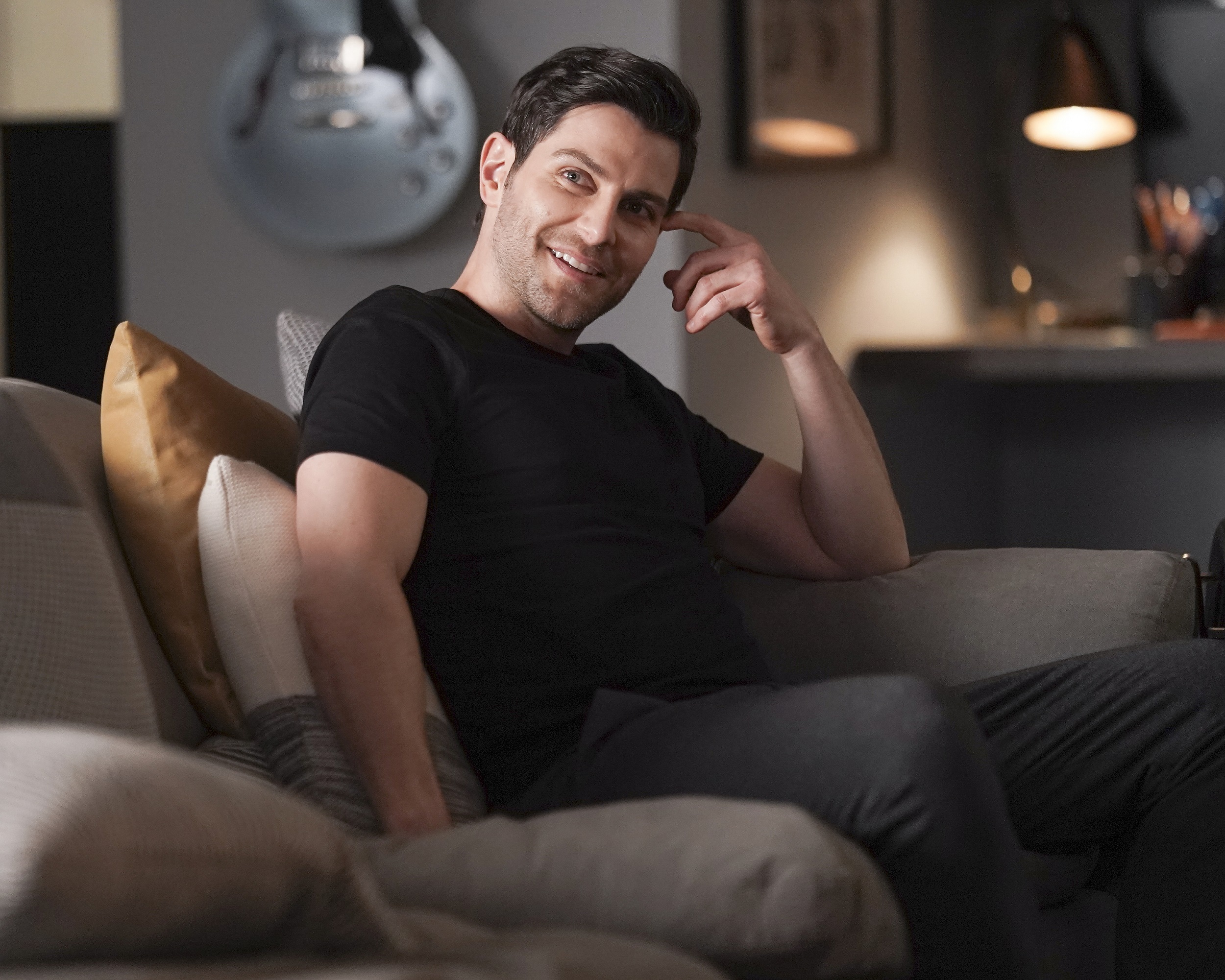 'A Million Little Things' David Giuntoli as Eddie Saville sitting on the couch smiling