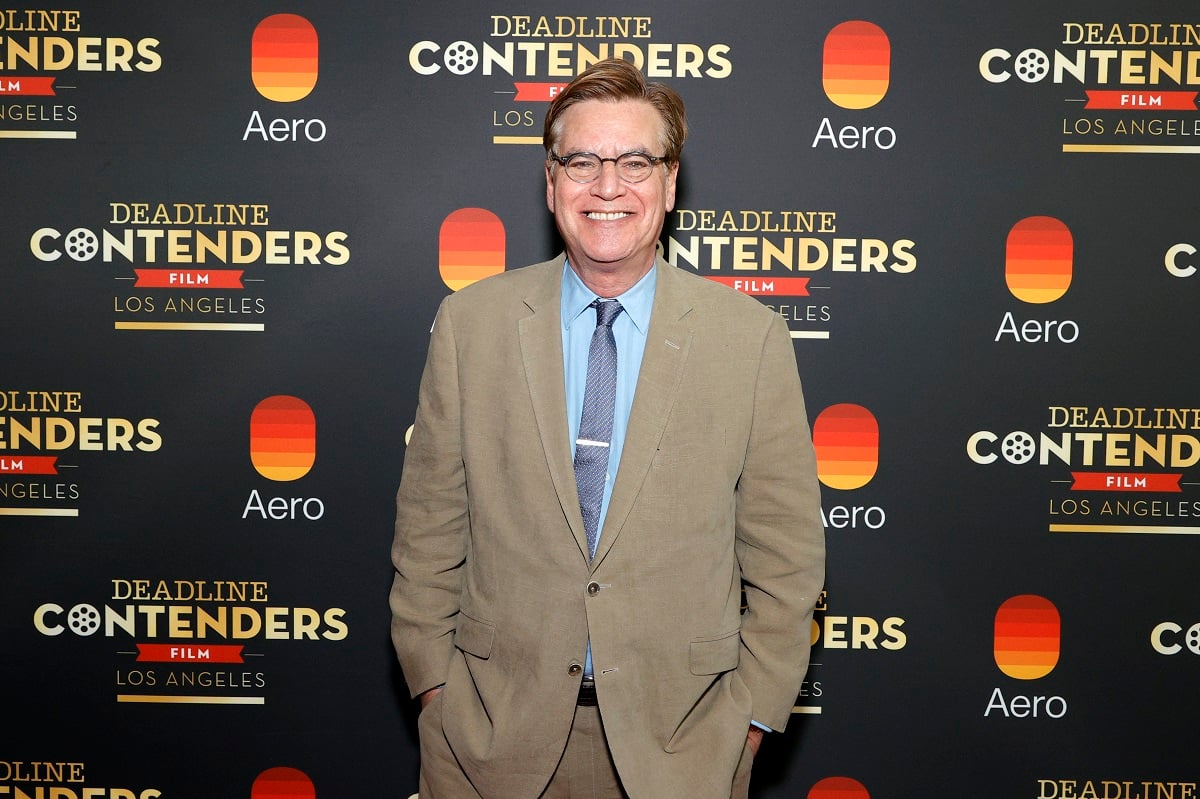 Aaron Sorkin smiling while wearing a suit.