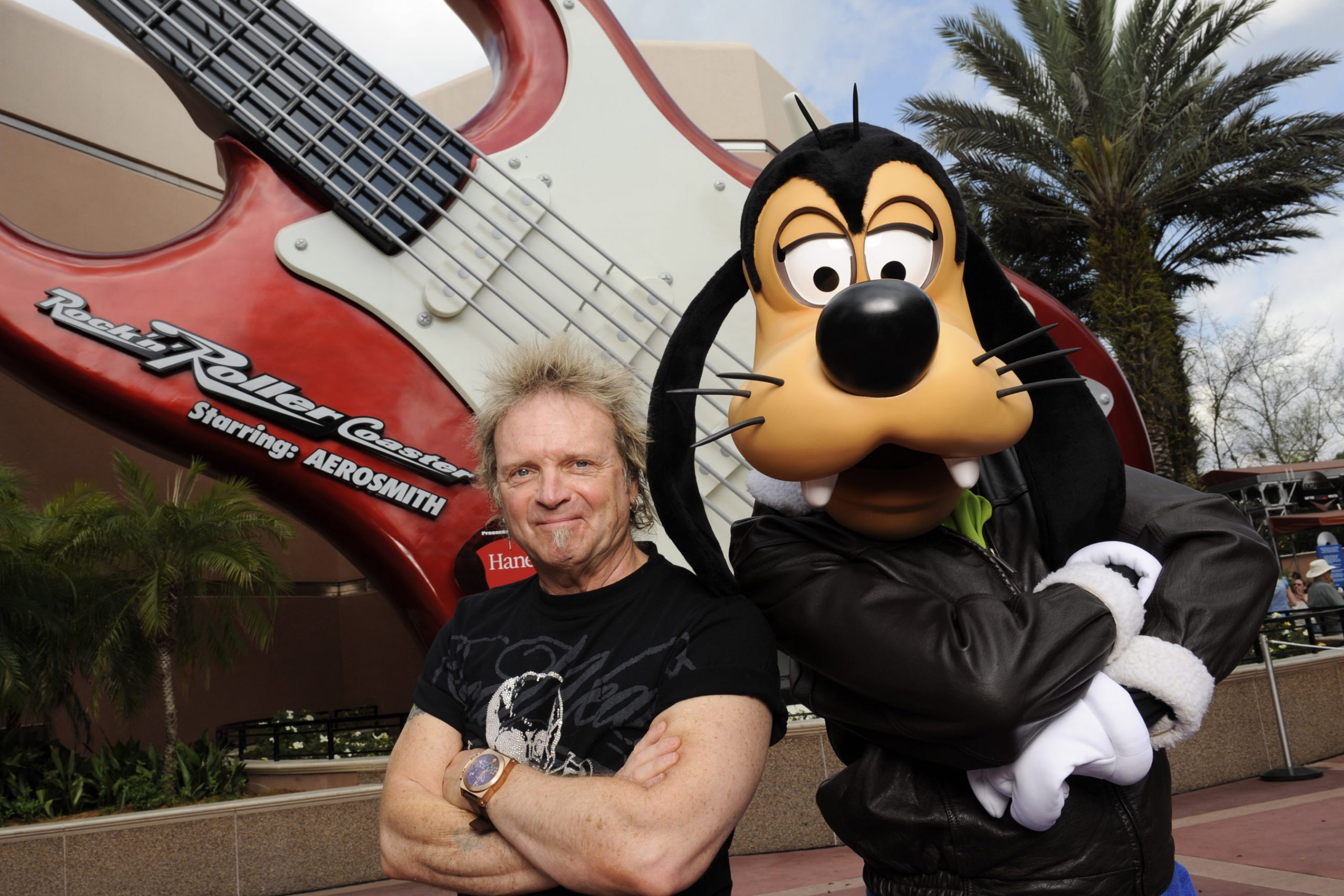 Aerosmith drummer Joey Kramer poses with Disney character Goofy at Disney's Hollywood Studios in front of the 'Rock 'n' Roller Coaster Starring Aerosmith'