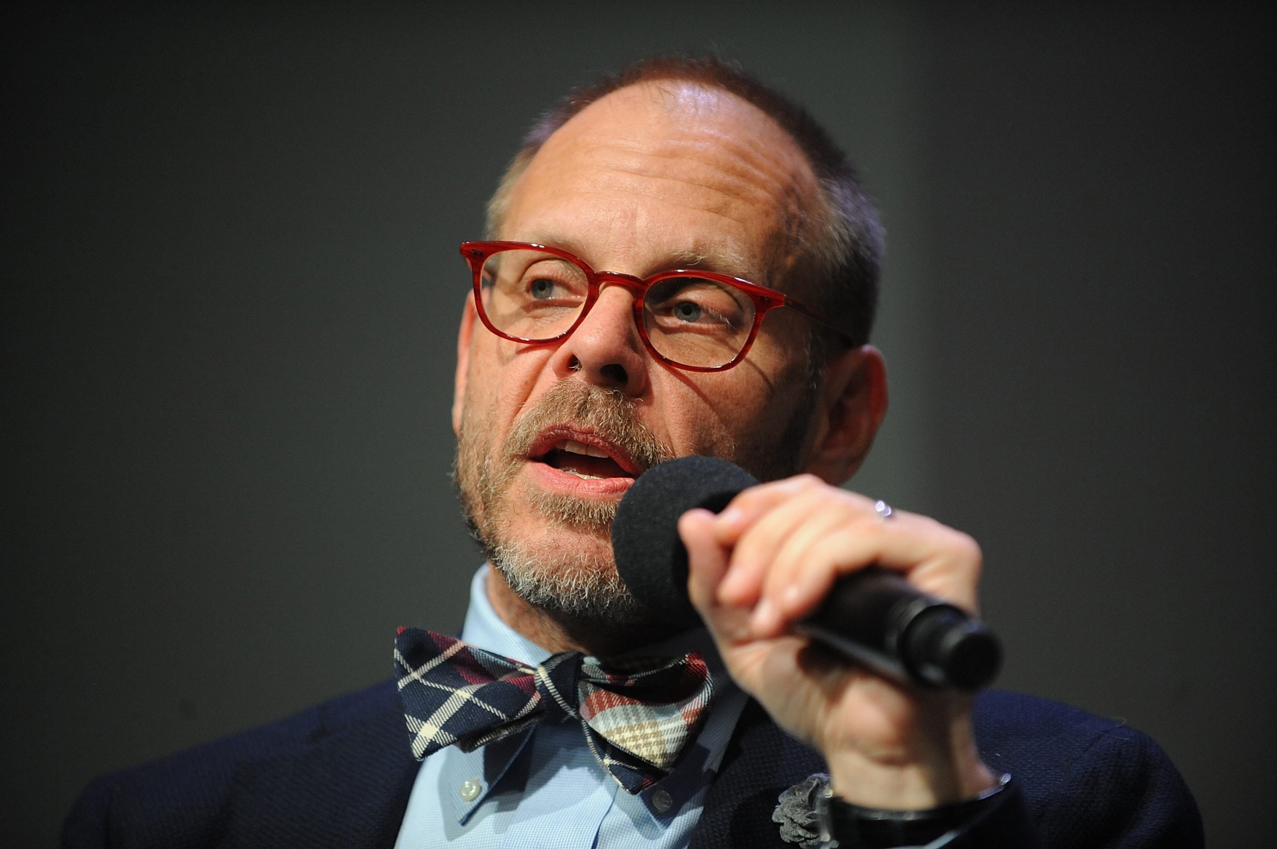 Chef Alton Brown wears a bow tie and suit in this photograph.