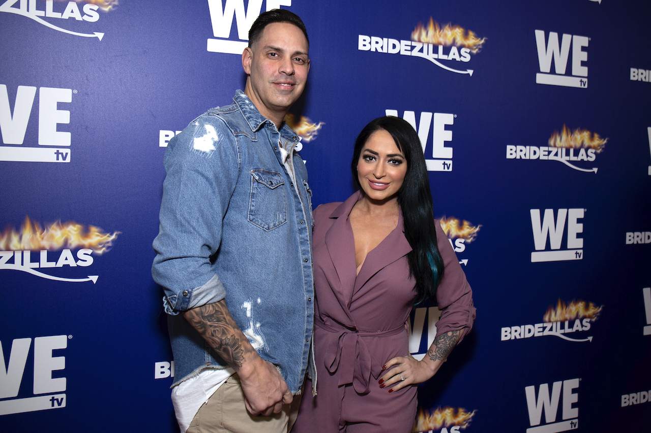 Chris Larangeira and Angelina Pivarnick pose together happily on a red carpet.
