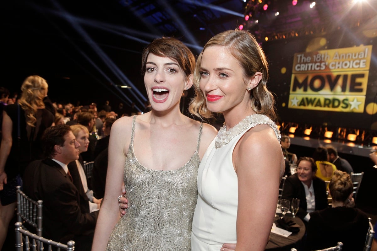 Anne Hathaway smiling alongside Emily Blunt