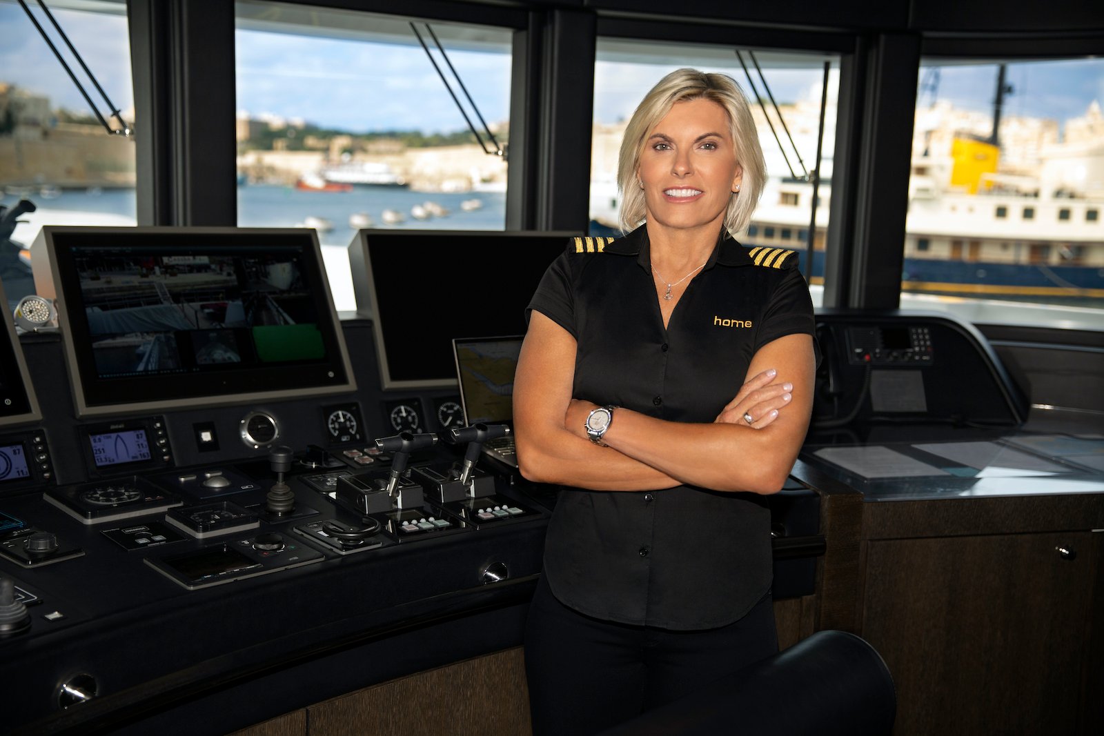 Captain Sandy Yawn from 'Below Deck Med' poses with arms crossed in the wheelhouse 