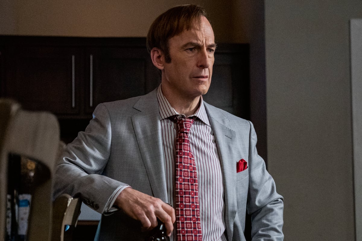 Bob Odenkirk as Saul Goodman in Better Call Saul Season 6. Saul wears a grey suit and red tie.