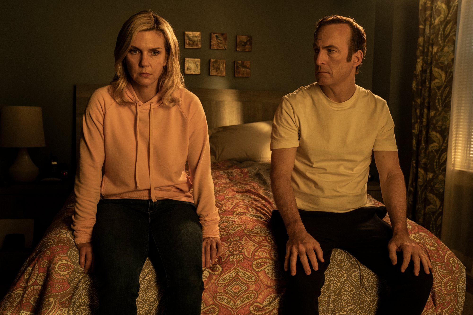 Rhea Seehorn and Bob Odenkirk in 'Better Call Saul' Season 6 Part 2, which has the same episode release schedule as part 1. They're sitting on a bed, and both look distressed.