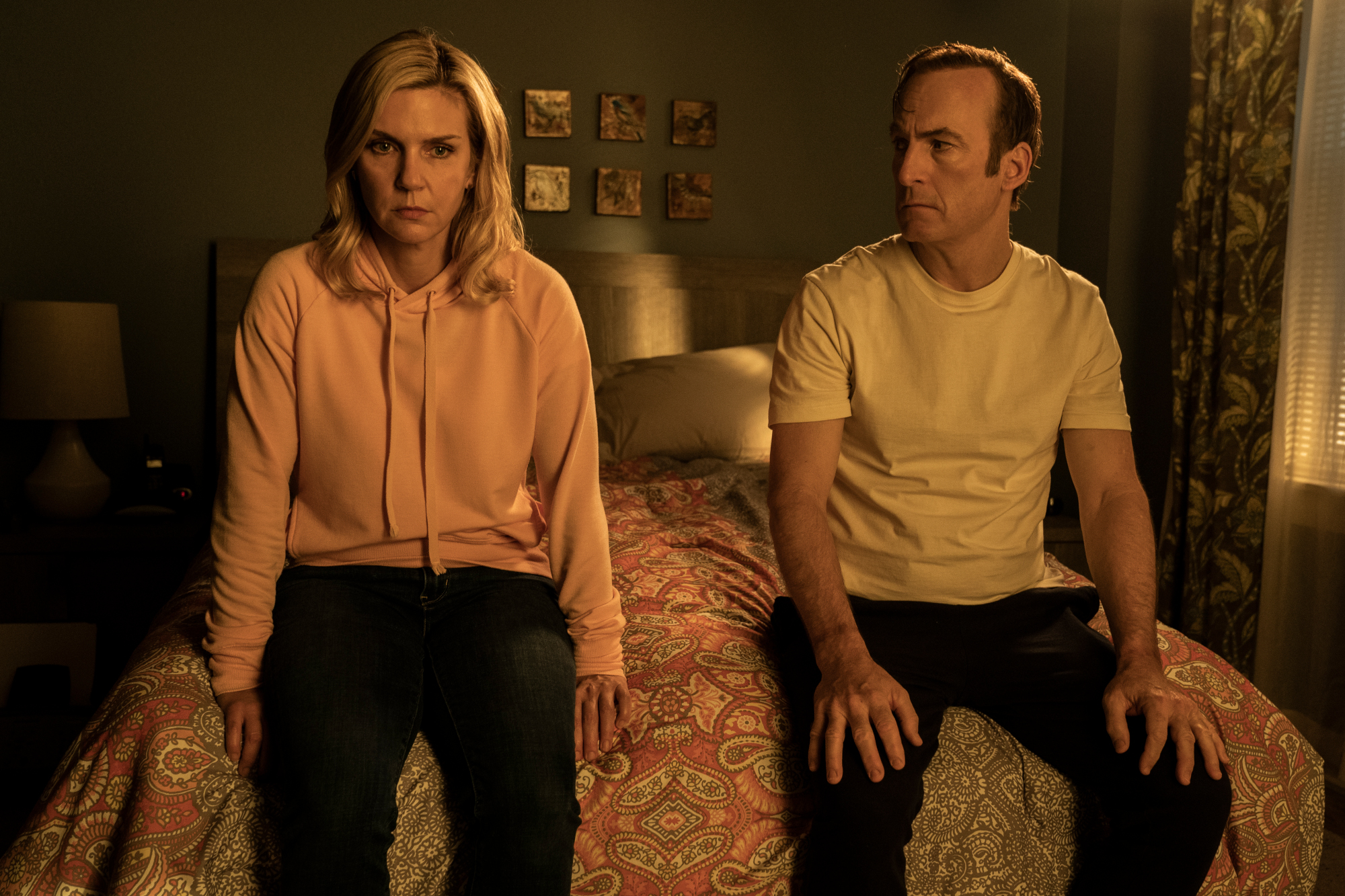 Rhea Seehorn and Bob Odenkirk in 'Better Call Saul' Season 6 Part 2, which has the same episode release schedule as part 1. They're sitting on a bed, and both look distressed.