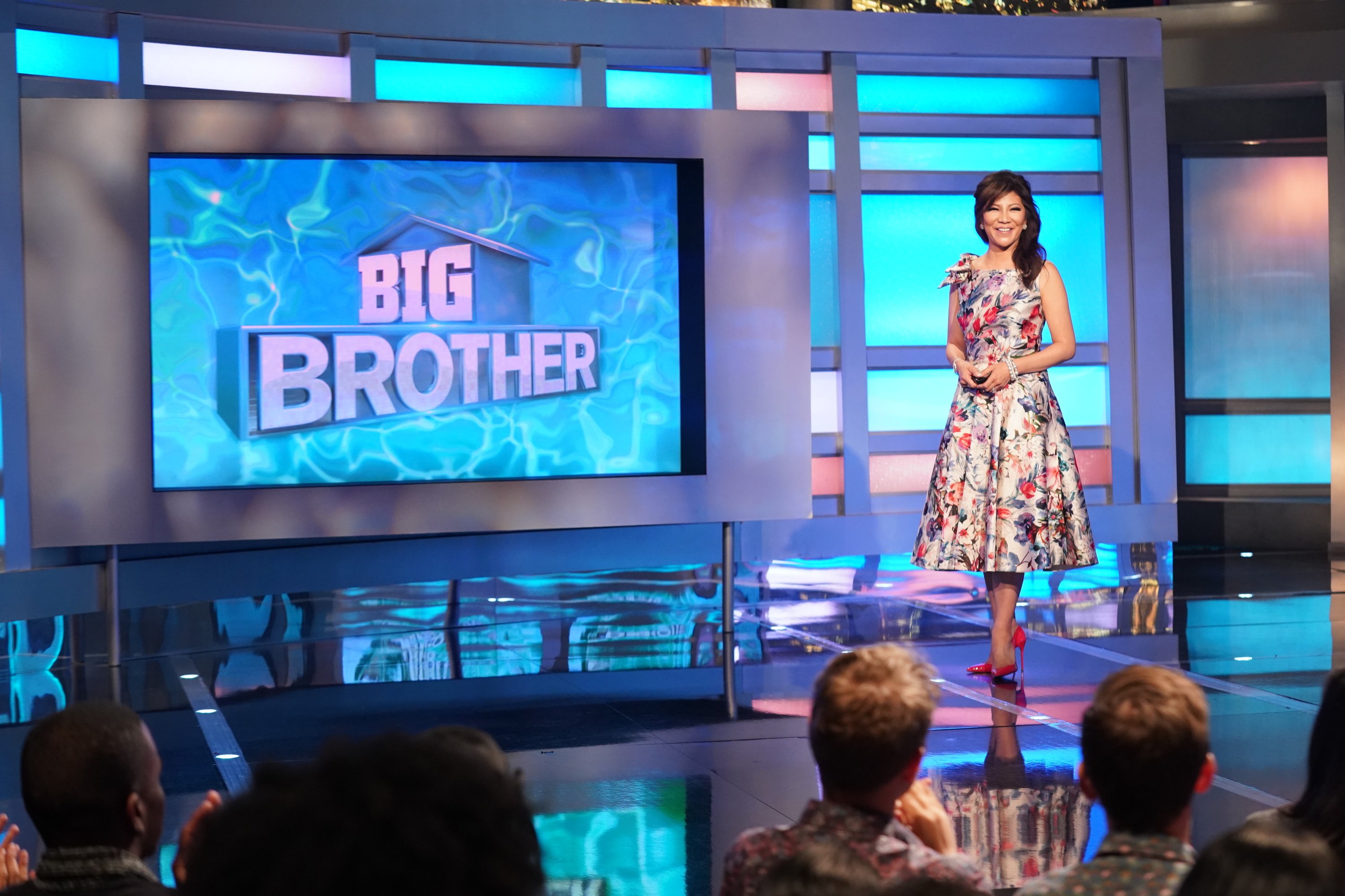 Julie Chen Moonves, who revealed the 'Big Brother' Season 24 twist, wears a red, green, and white floral dress on the 'Big Brother' stage.