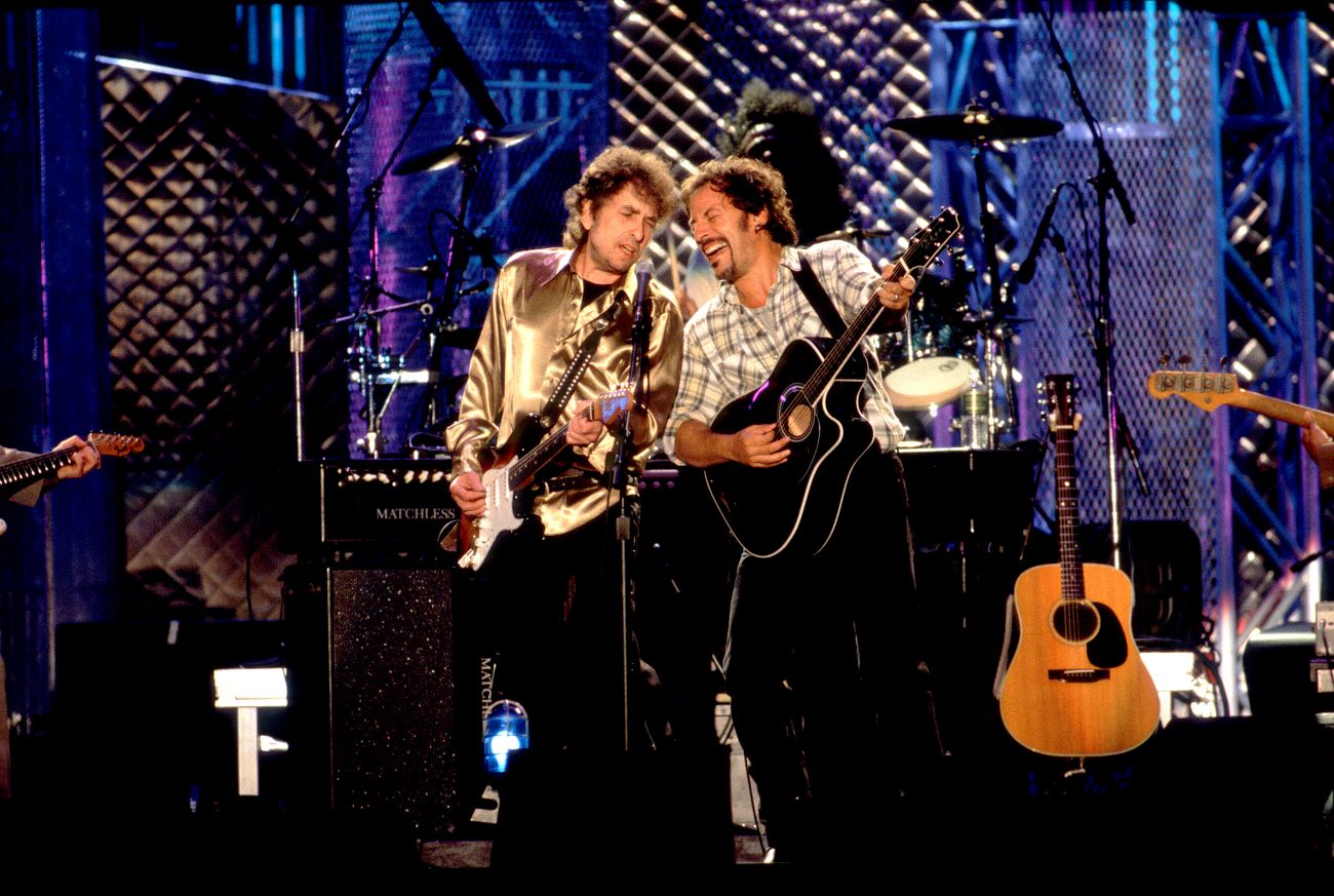 Bob Dylan and Bruce Springsteen both play guitar and sing into the same microphone. 