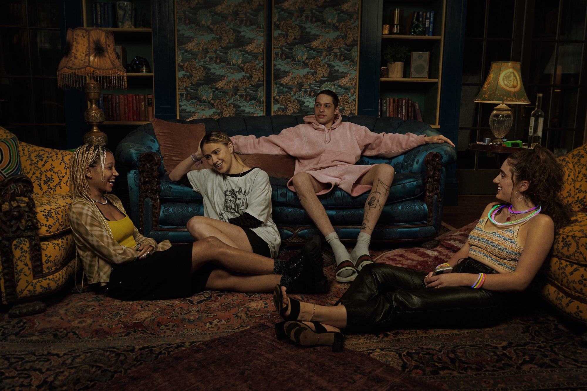 'Bodies Bodies Bodies' game slasher movie Sophie (Amandla Stenberg), Bee (Maria Bakalova), David (Pete Davidson), and Alice (Rachel Sennott) sitting in an extravagant sitting room on couches