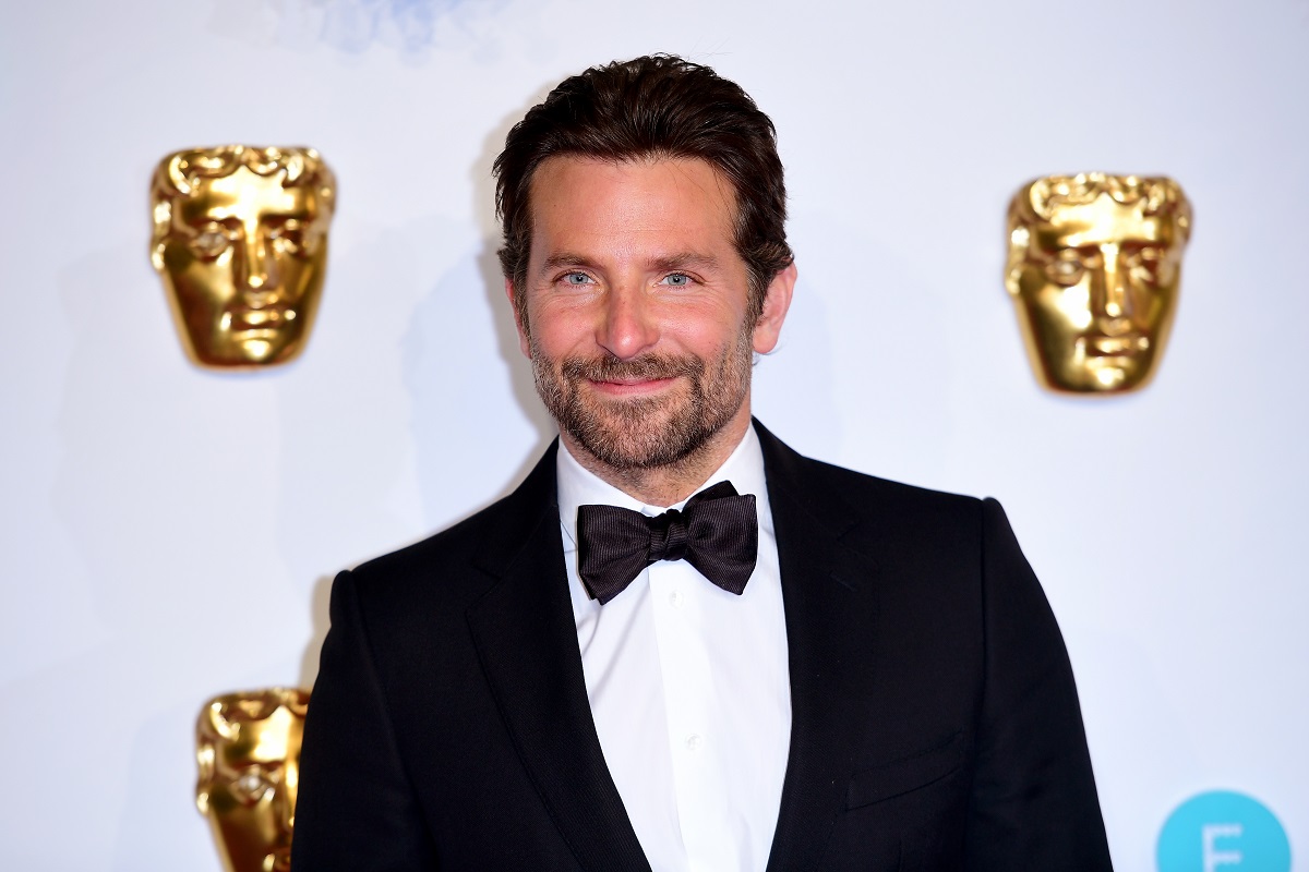 Bradley Cooper smiling while wearing a suit.