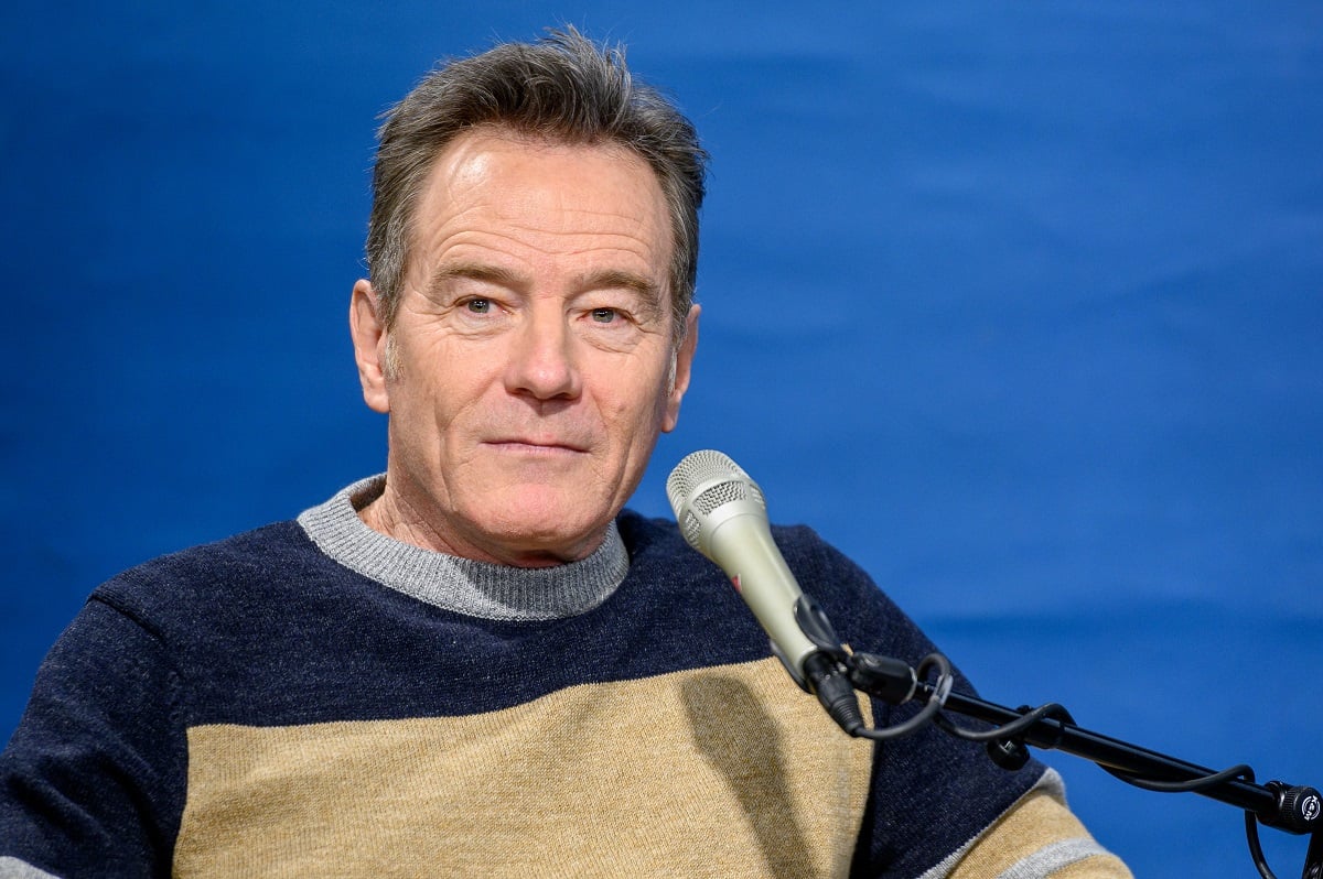 Bryan Cranston sitting down while in front of a microphone.