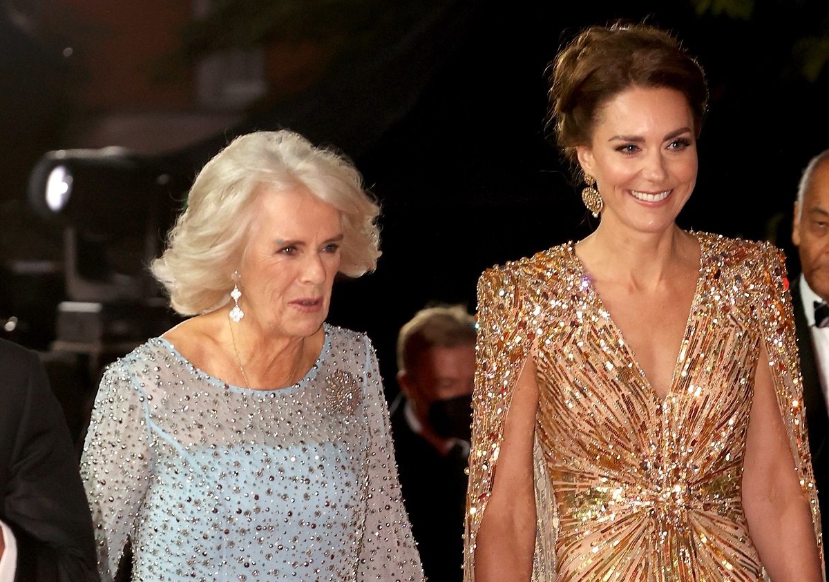 Kate Middleton and Camilla Parker Bowles, who a body language expert says had mixed feelings about being photographed, walk the red carpet at the 'No Time To Die' world premiere