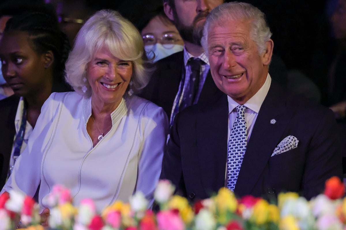 Camilla Parker Bowles and Prince Charles, who according to Camilla Parker Bowles make time for their marriage by talking about their days over tea, smile as they sit next to each other