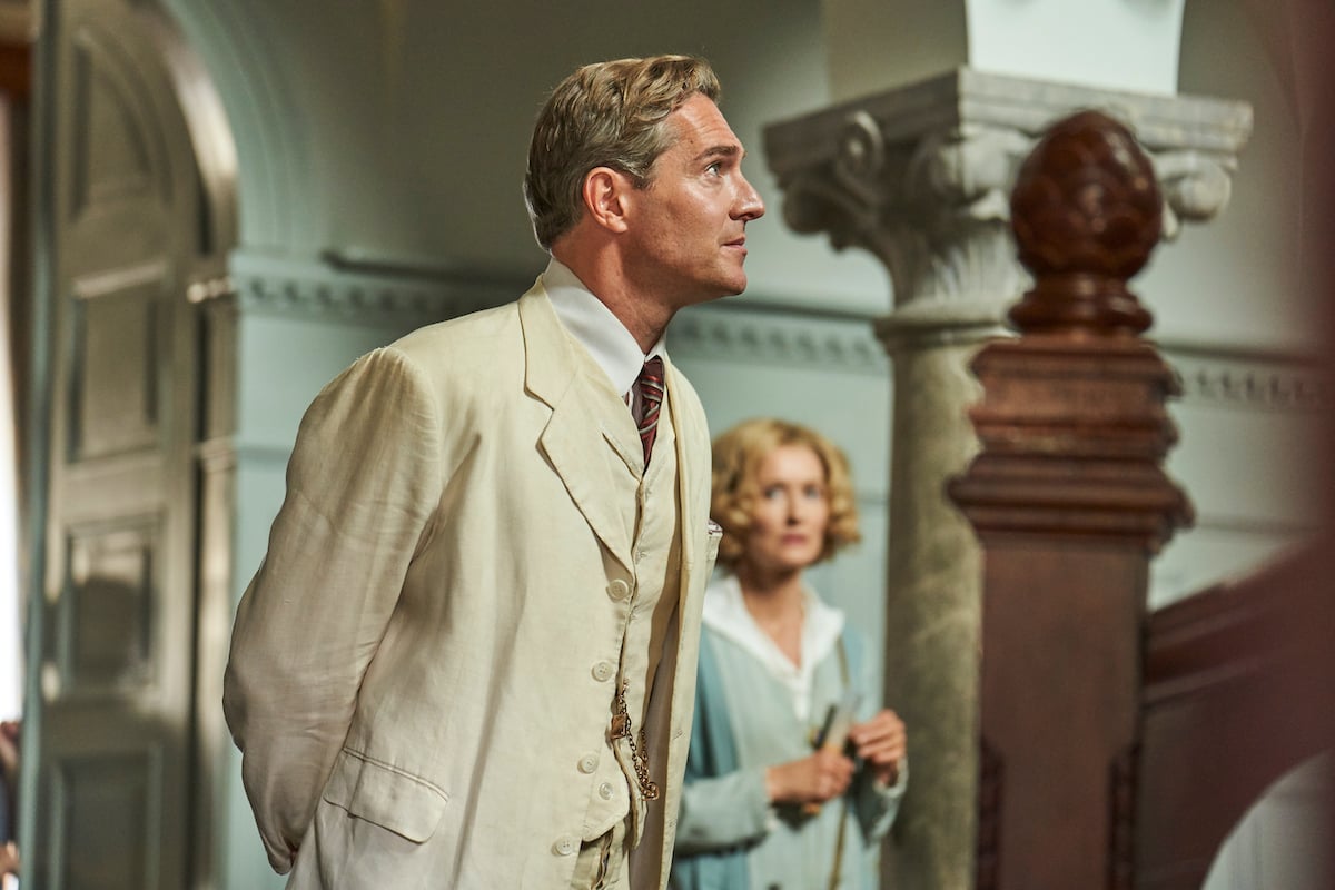 Cecil in a white suit with Bella in the background in 'Hotel Portofino'