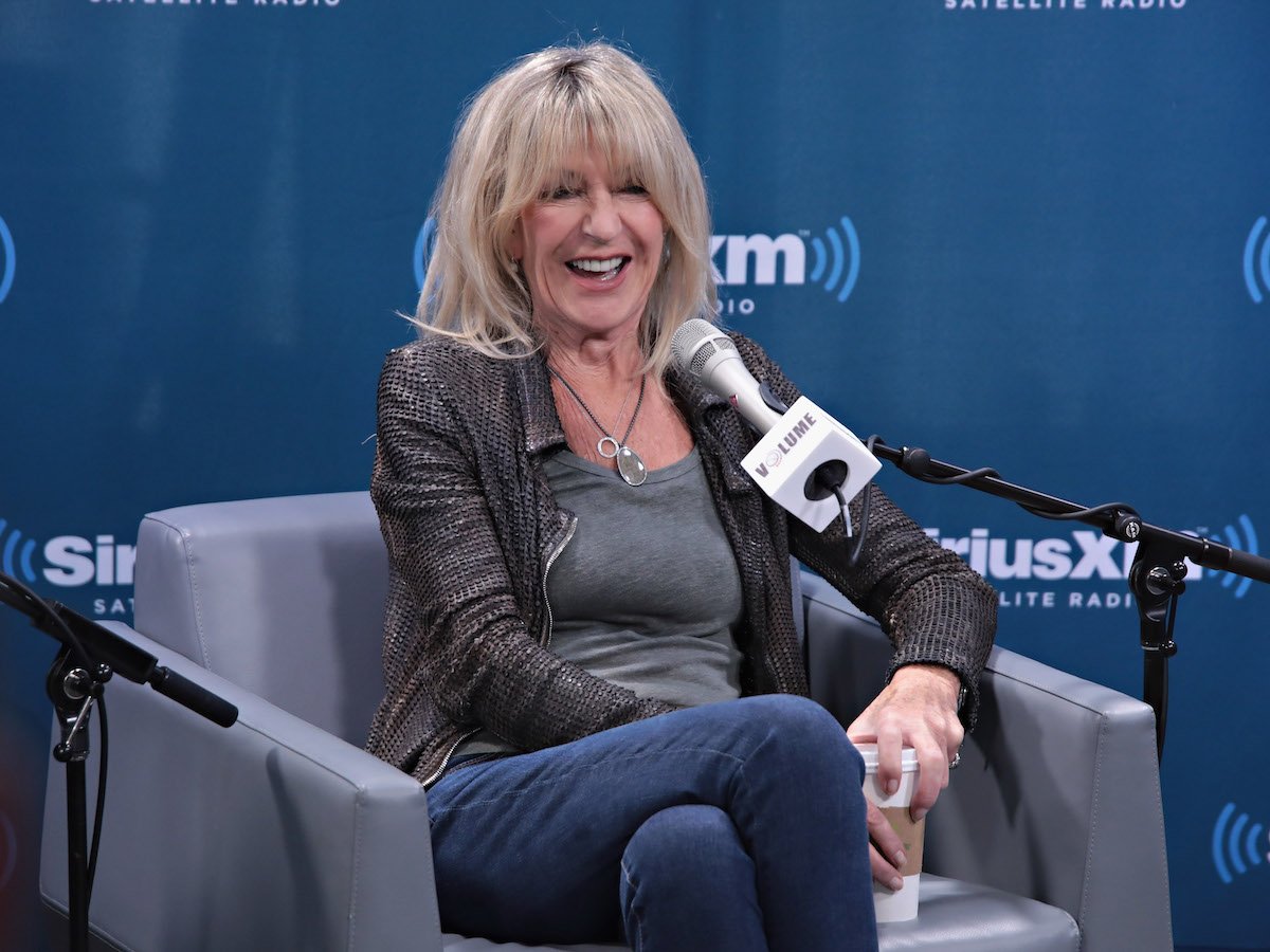 Christine McVie smiles into a microphone during an interview.