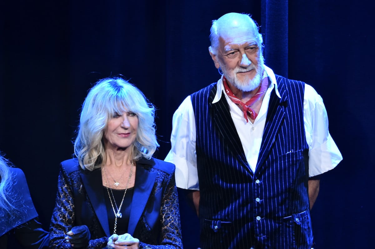 Christine McVie and Mick Fleetwood of Fleetwood Mac stand together on stage.