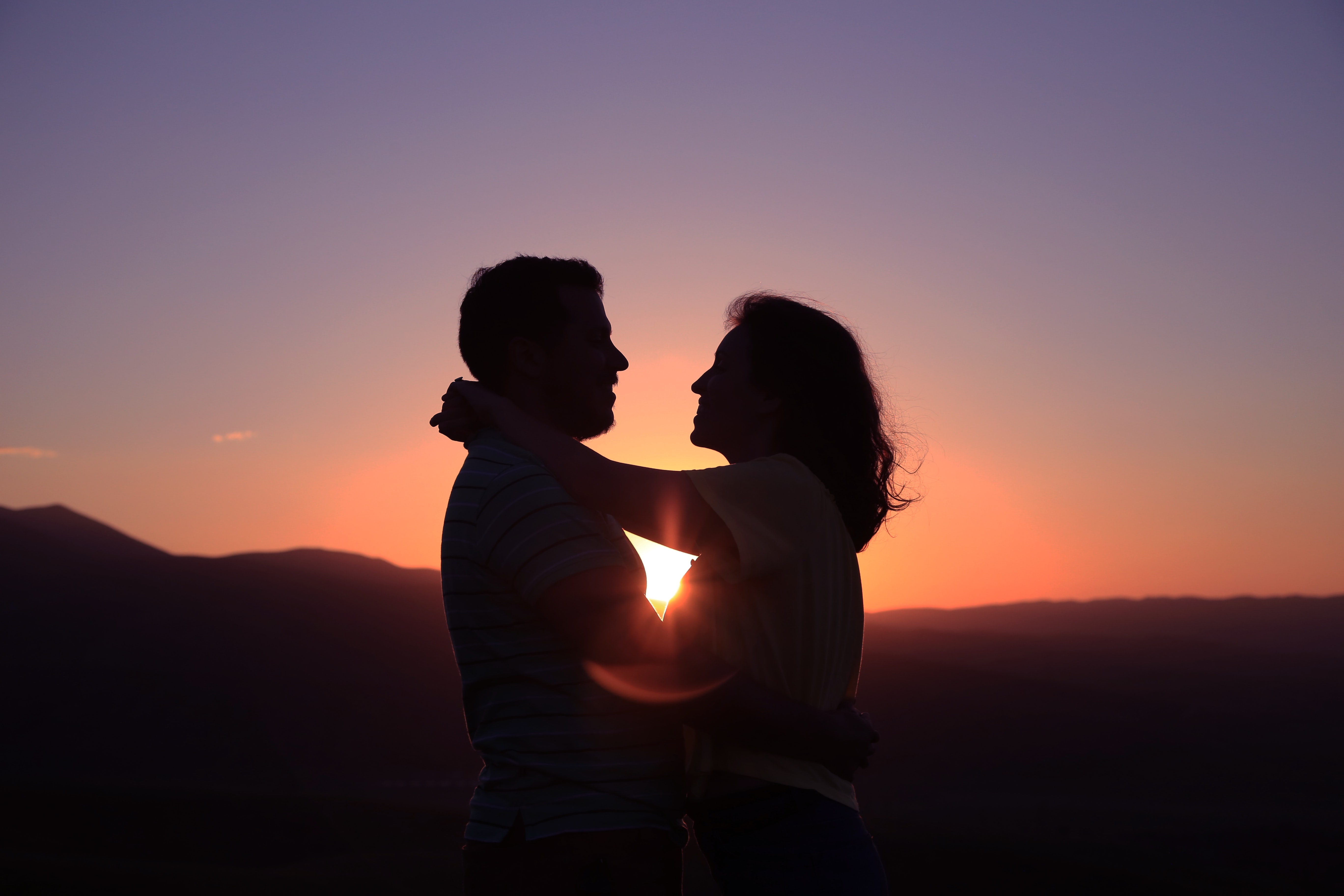 A couple embraces on the beach.