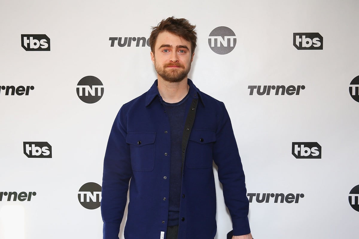 Daniel Radcliffe posing while wearing a blue shirt and jacket.