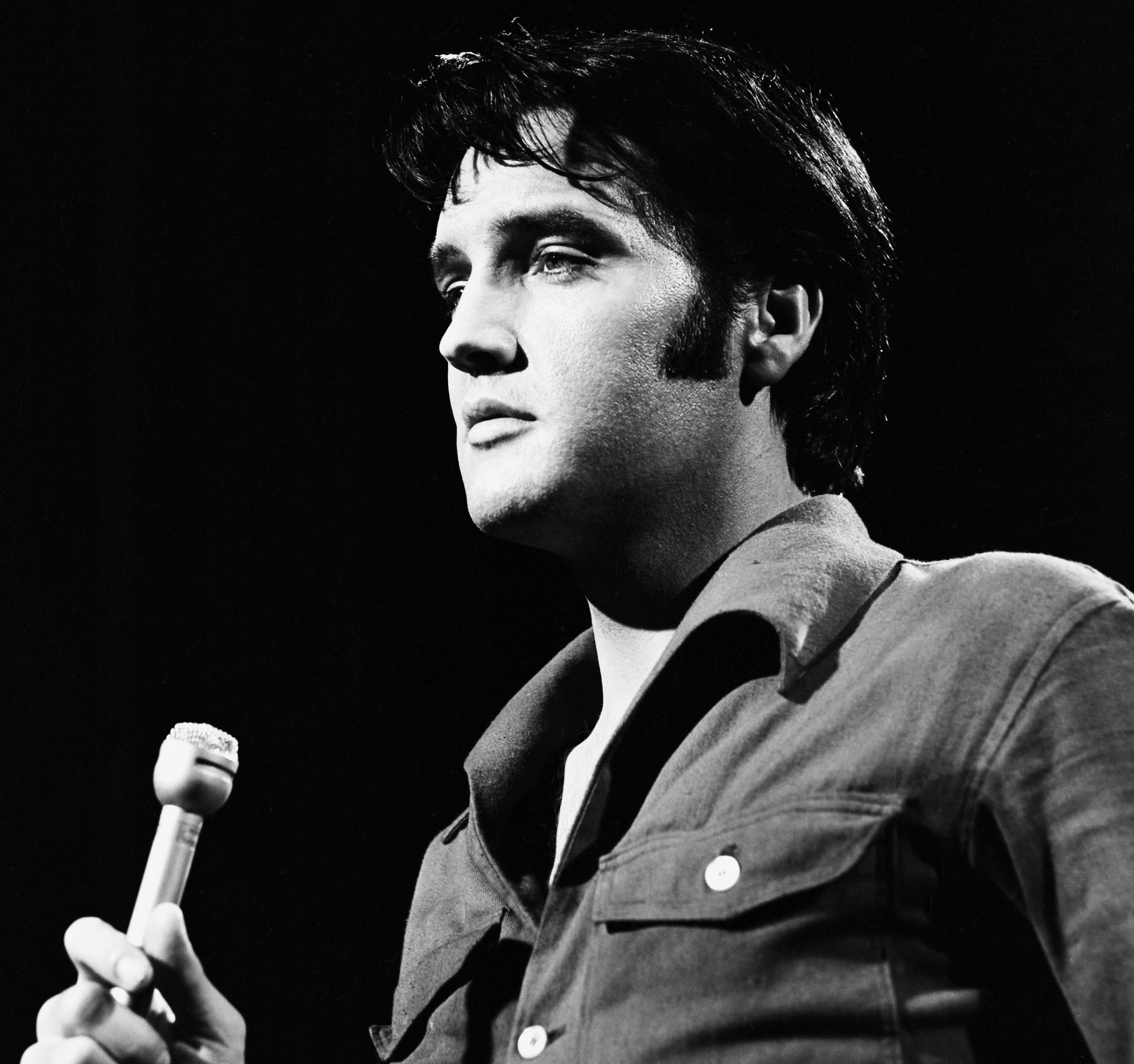 Elvis Presley performing songs into a microphone