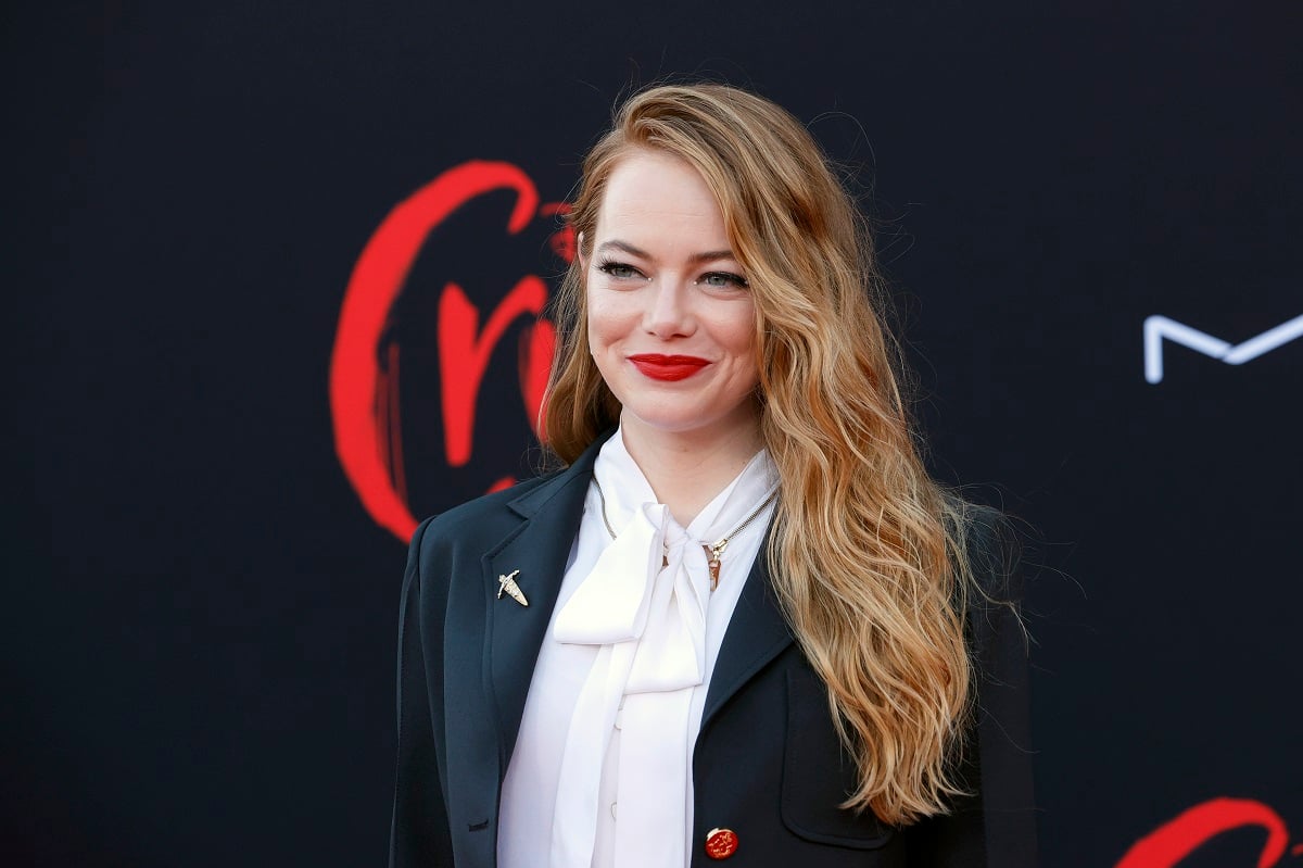 Emma Stone smiling while wearing a suit.