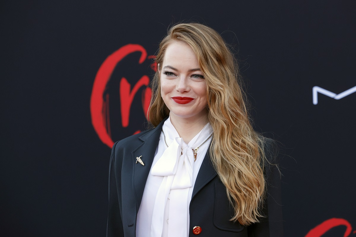 Emma Stone smiling while wearing a suit.