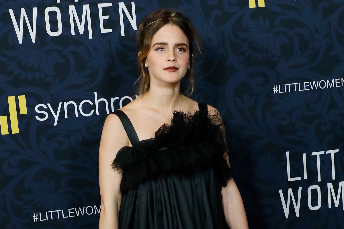 Emma Watson posing while wearing a black dress.