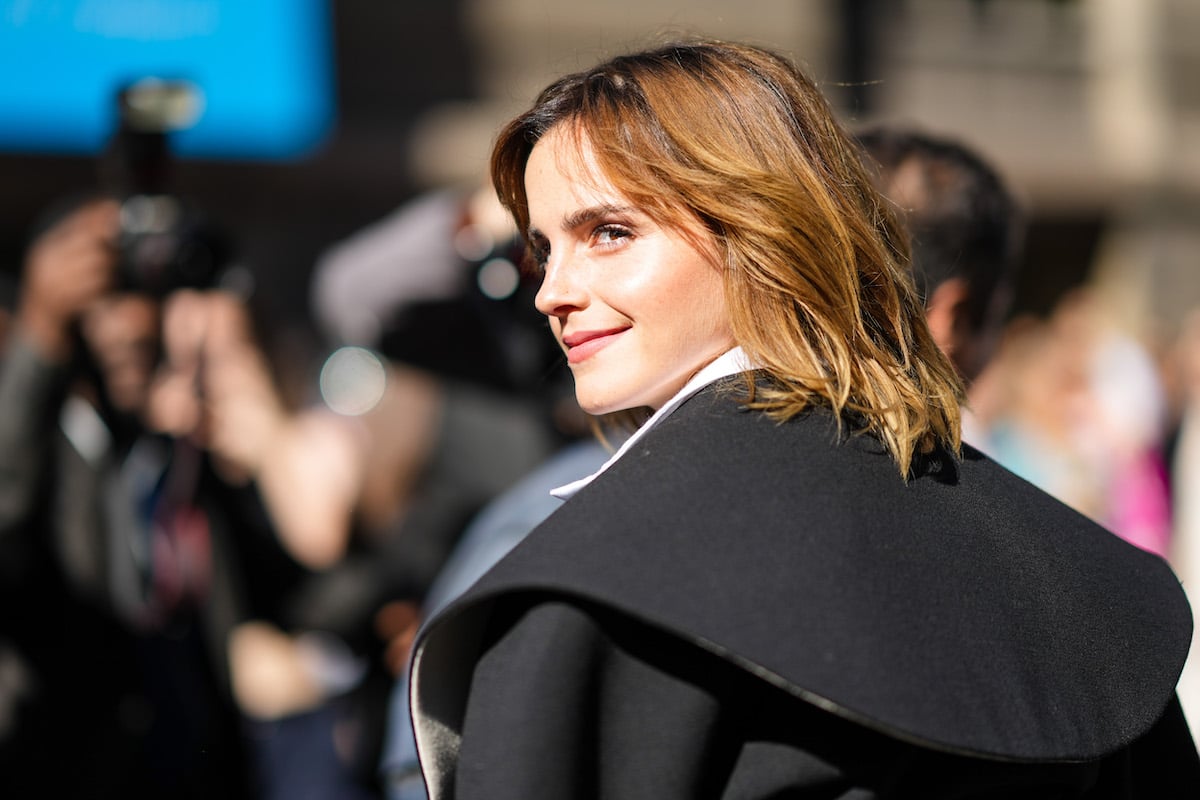 Emma Watson looks over her shoulder in a black jacket