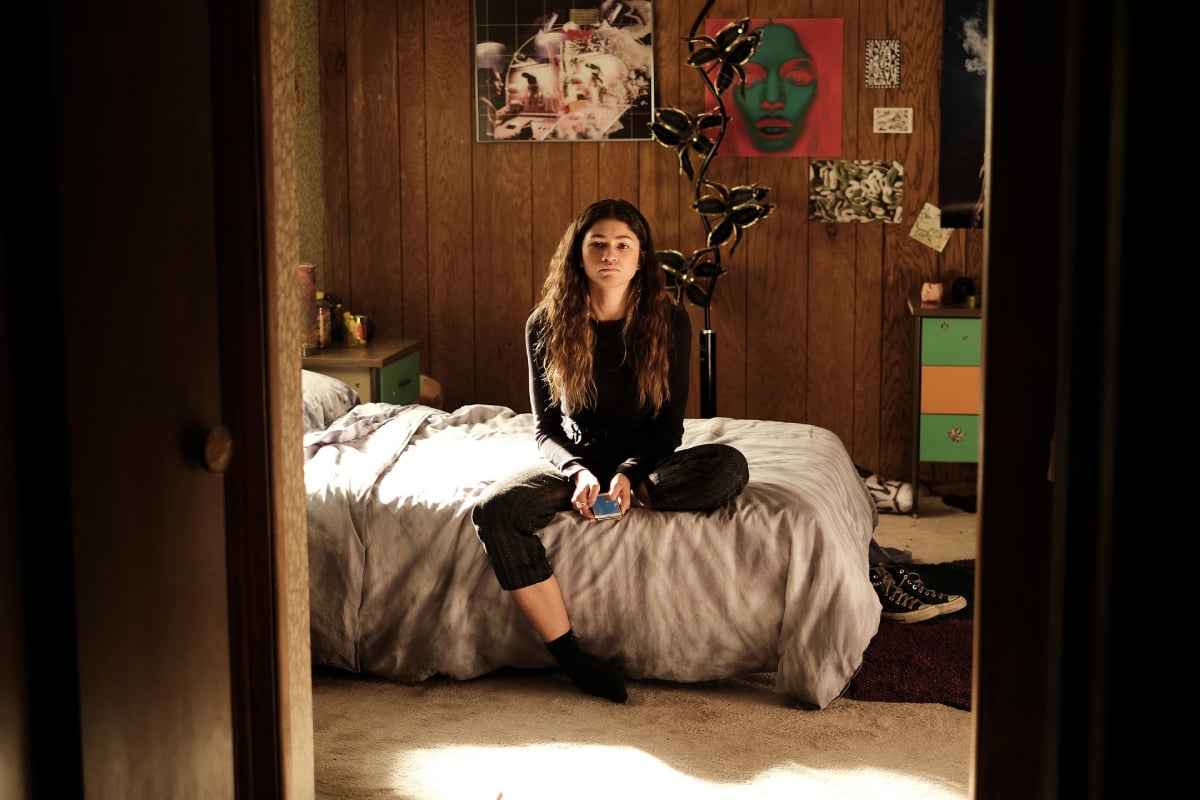 Euphoria has been renewed for season 3. Rue Bennett sits in her room and looks through the open door.