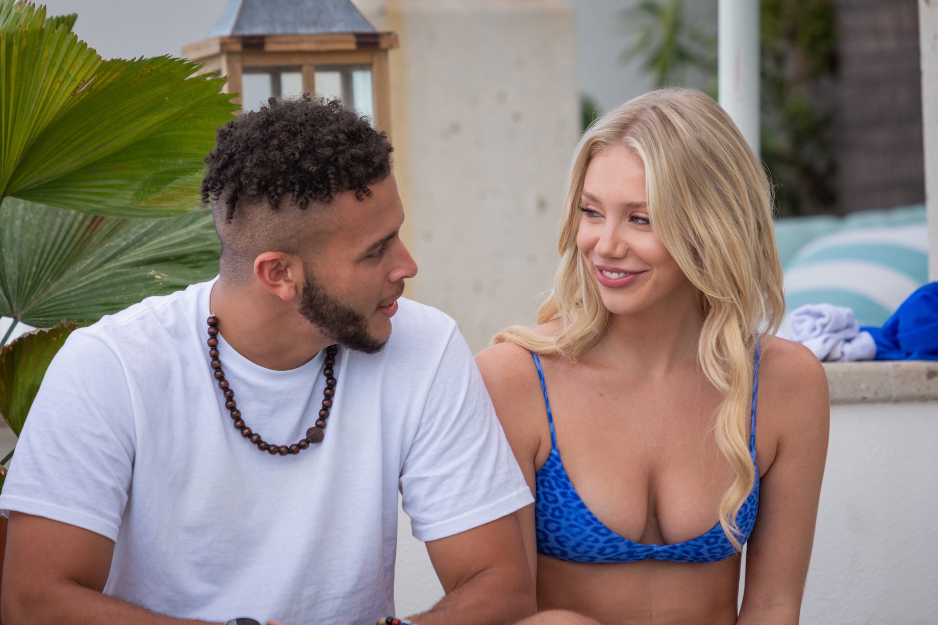 'FBoy Island' Season 2: Kyland Hewett-Newbill and Louise Barnard sitting together and smiling at each other