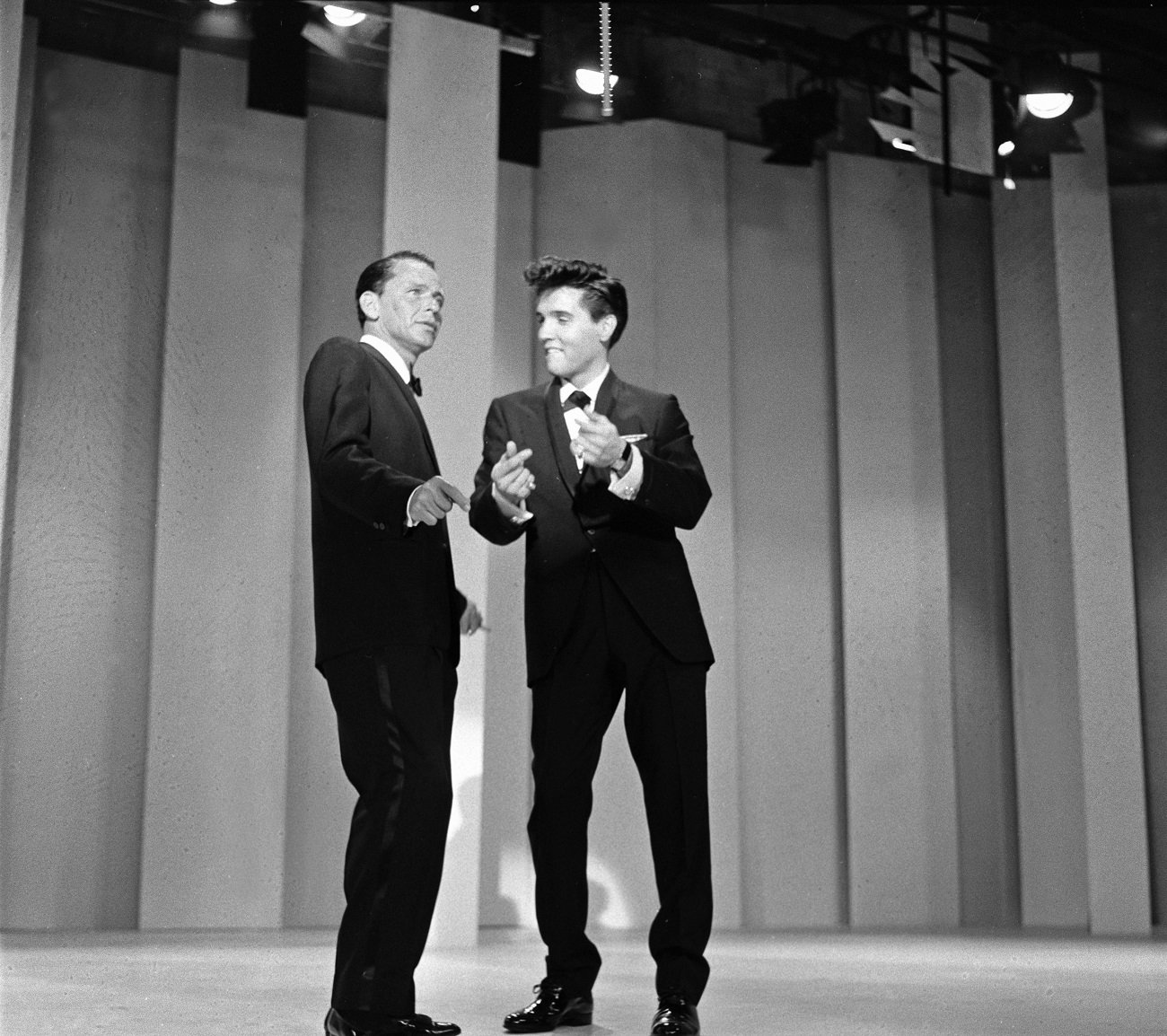 A black and white photo of Frank Sinatra and Elvis wearing tuxedos during a television special.